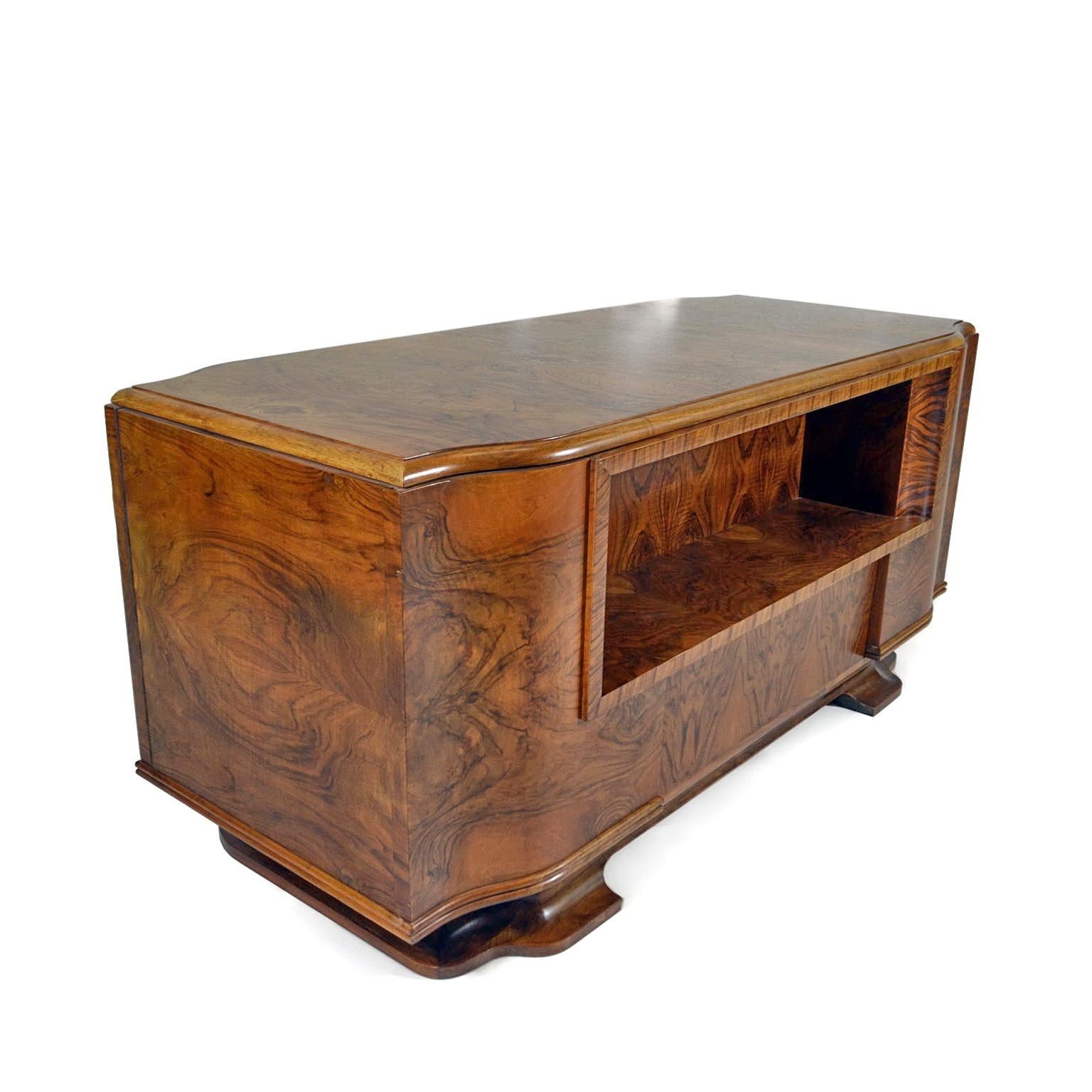Stunning large Art Deco desk made of solid wood veneered in French walnut and mahogany, moved contour creating a slender look, yet a massive, impressive body, sitting on rounded feet. Beautiful front space to store books or decorative items,