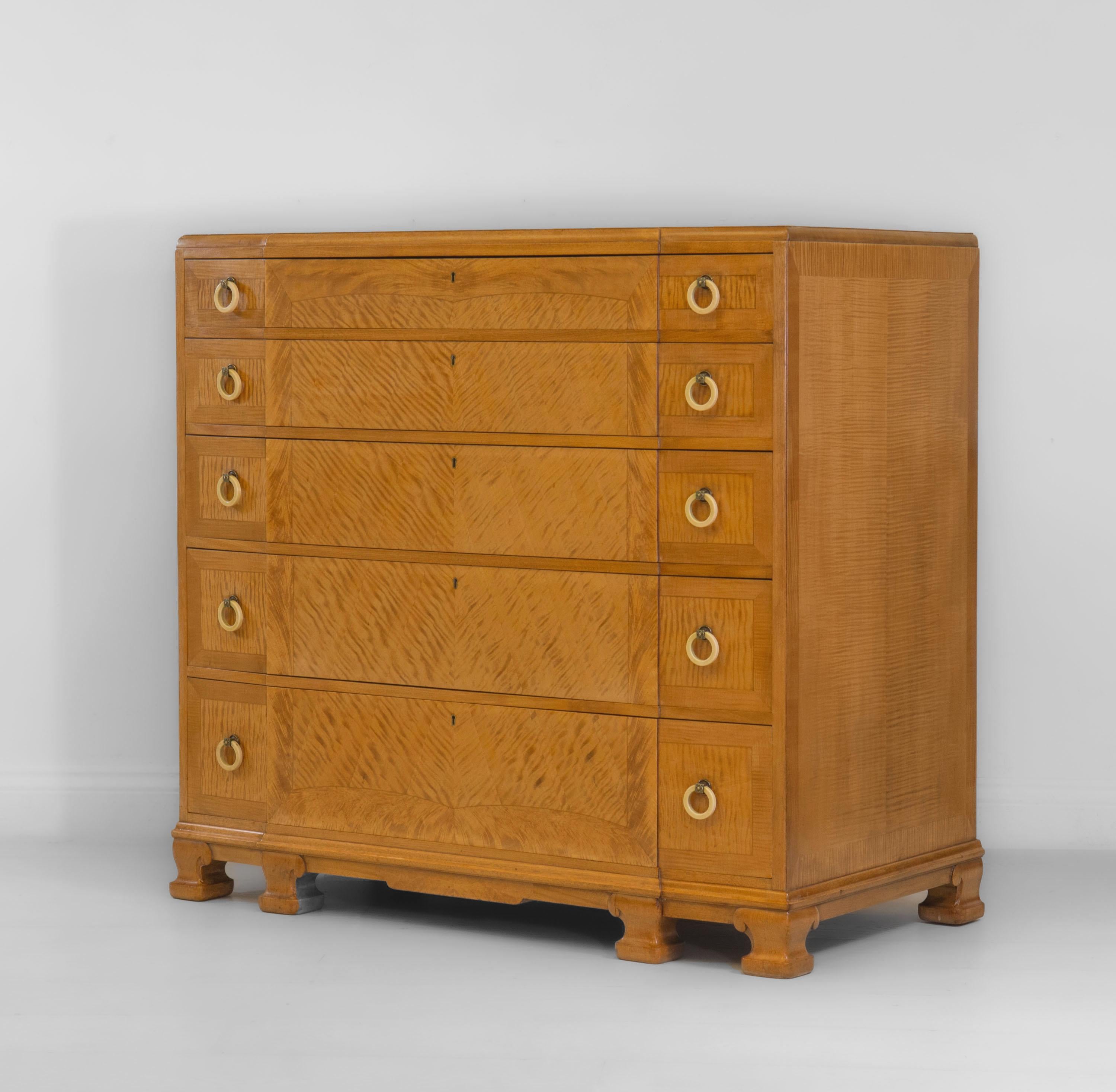An exceptional British Art Deco figured maple chest of drawers. Circa 1930. Locks stamped 'Langbear Birmingham'.

The chest of drawers has a break front design and is veneered in highly figured quartered book match maple, as well as line inlaid and