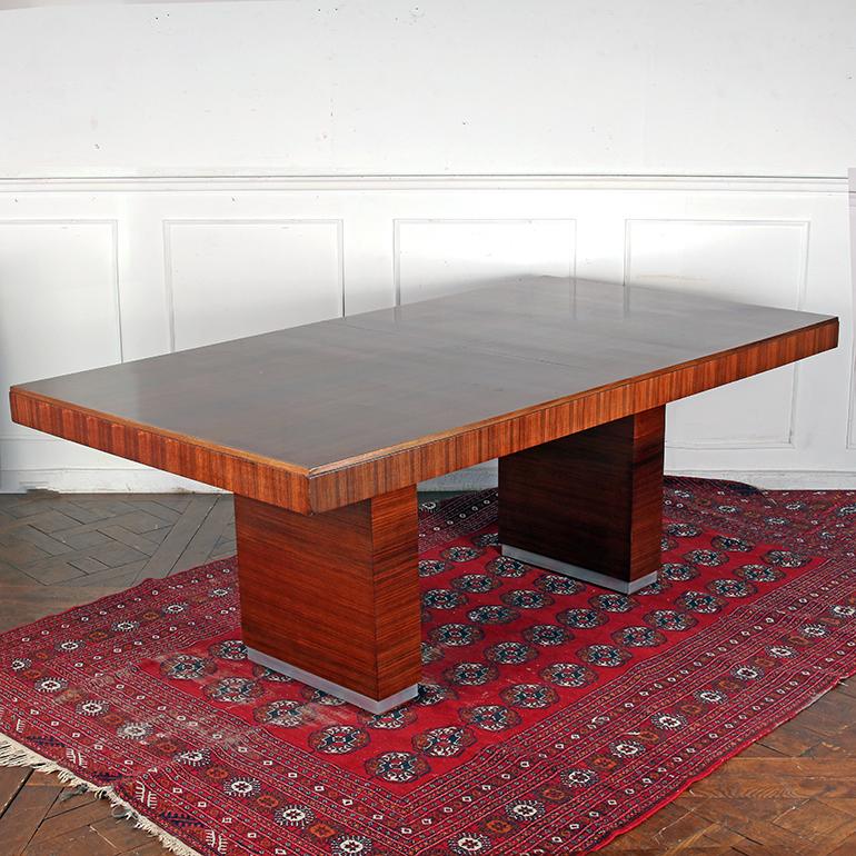 An exceptional Rosewood dining table with a sophisticated, timeless design that demonstrates perfectly the transition in design trend from Art Deco, which ended around 1940, and Mid-Century Modern, which began in the mid 1940s. Professionally