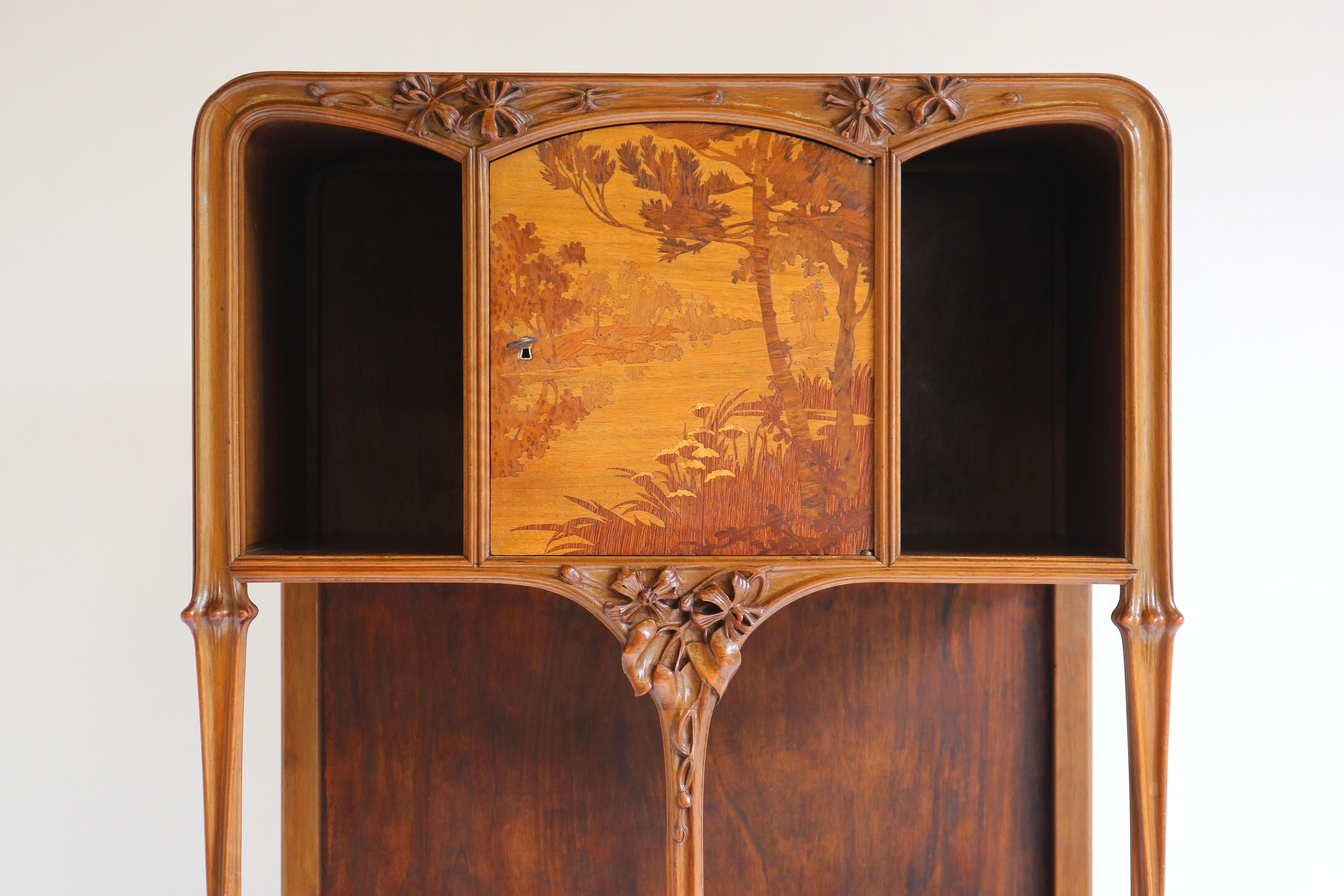 Exquisite & breathtaking! This French antique Art Nouveau cabinet / etagere by Louis Majorelle 1900 Nancy France. 
The upper door inlaid in various woods with a landscape, on carved supports with larger cupboard below, the door inlaid with irises,