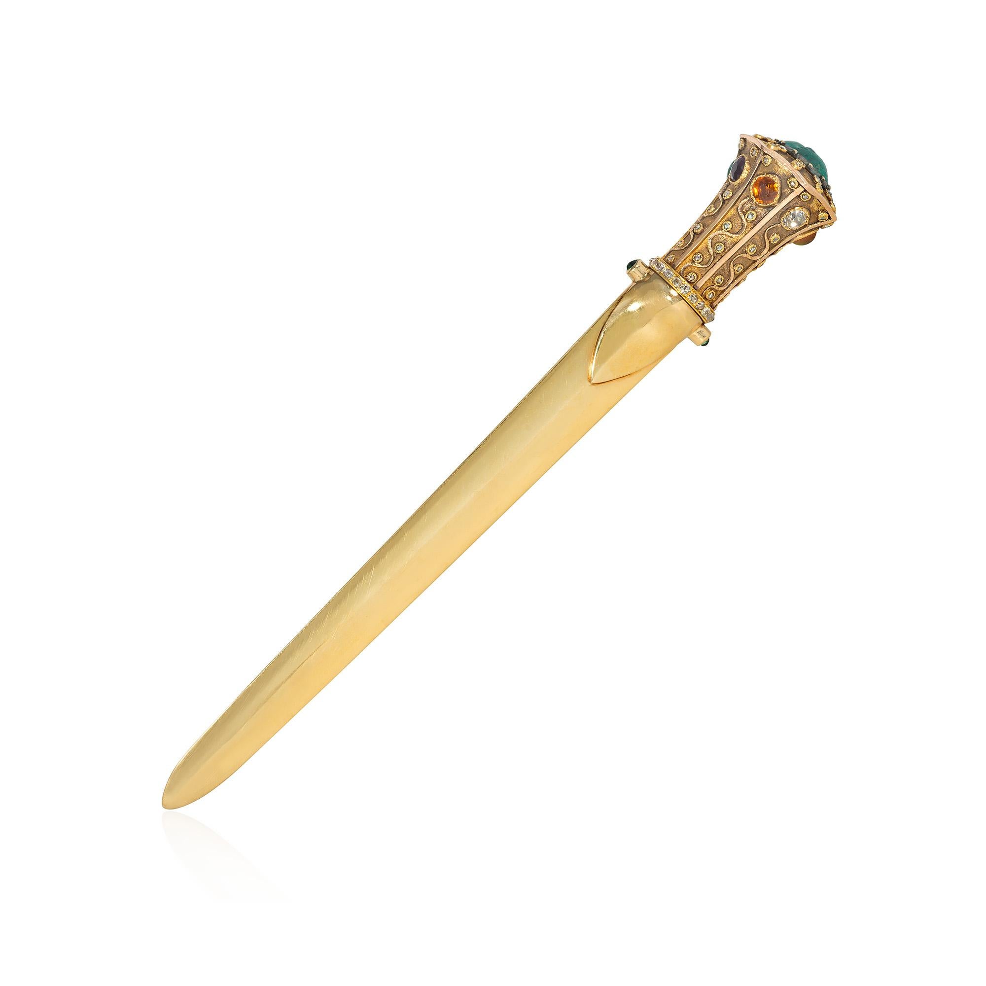 An important Art Nouveau gold and multi-gemstone letter opener in the form of a dagger.  The hilt is decorated with applied wirework and granulation and set with diamonds, fire opal, sapphire, ruby, emeralds, onyx and citrine, terminating in a