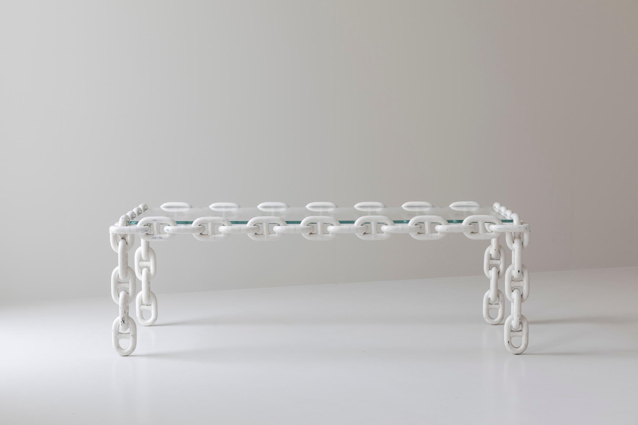 This exceptional artisan coffee table, crafted in Belgium during the 1970s, is a striking example of bold, sculptural design. Featuring large chain links made of off-white enameled iron, this table’s unique form is complemented by a beveled glass