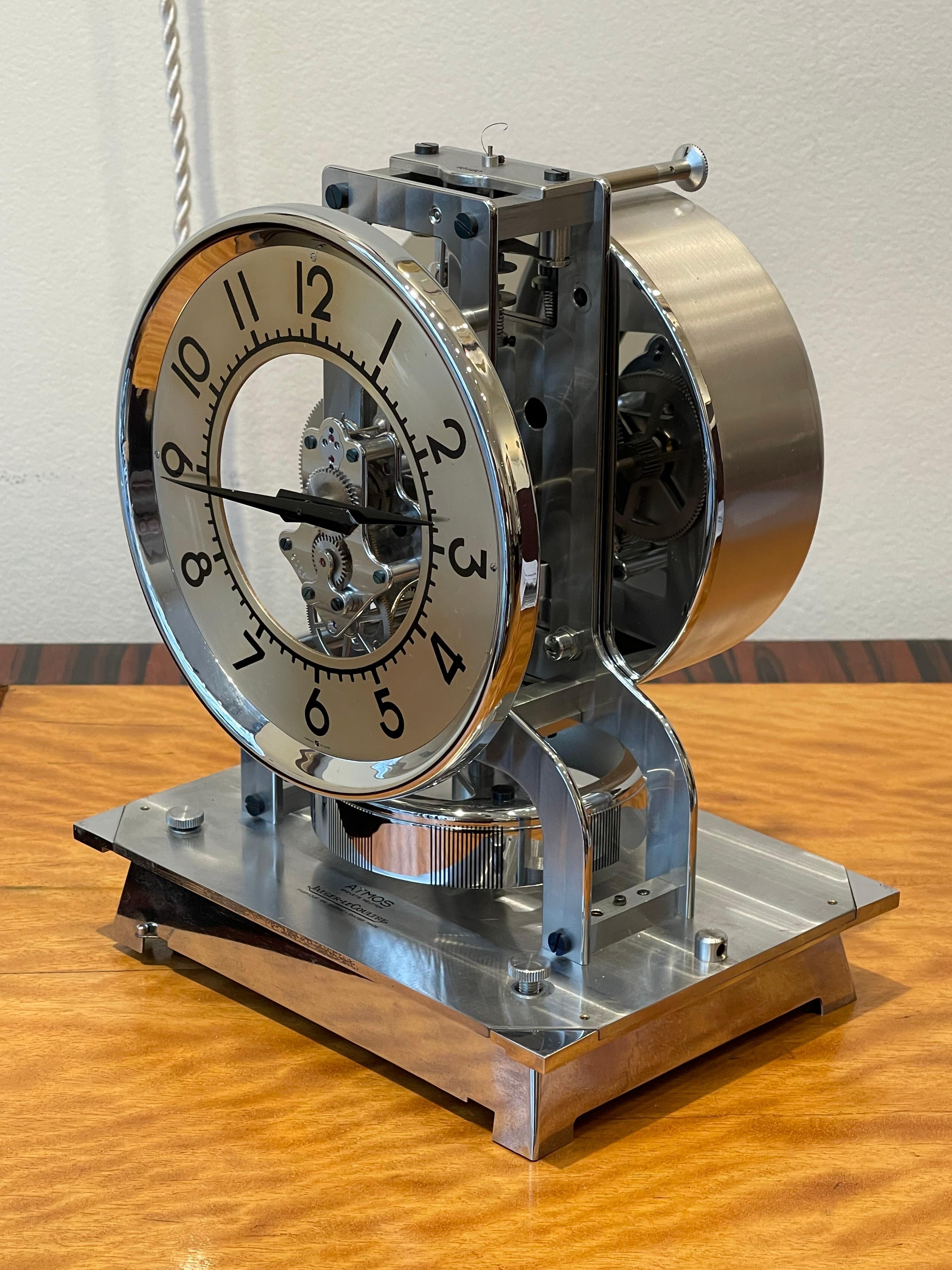 Exceptional  Atmos Table Clock by Jaeger-Lecoultre, circa 1940, Switzerland

Eternal table clock in chrome metal. The clock sits on a chrome metal base, covered by a wooden cube. The dial is hollow in the center with an exposed mechanism, and the