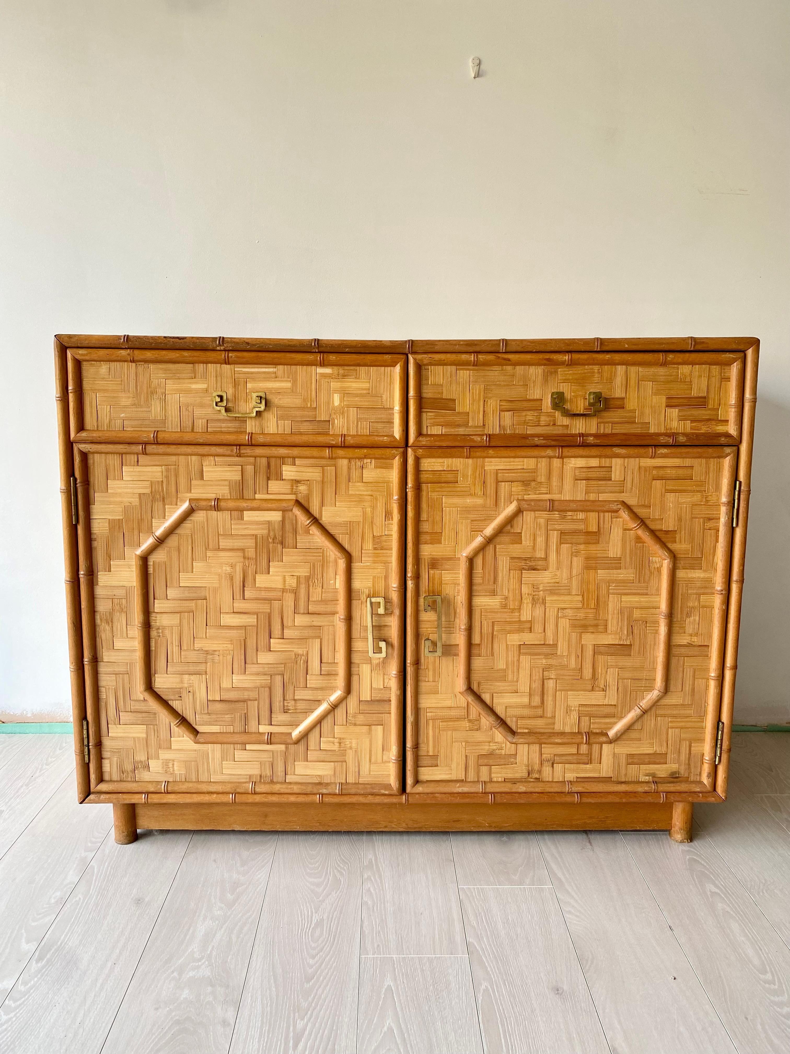 A stunning mid century rattan and bamboo sideboard

In good vintage condition with aged brass handles

Slight discolouration to the top as per close up images

Measures: 114cm wide, 47cm deep, 90cm tall.
 