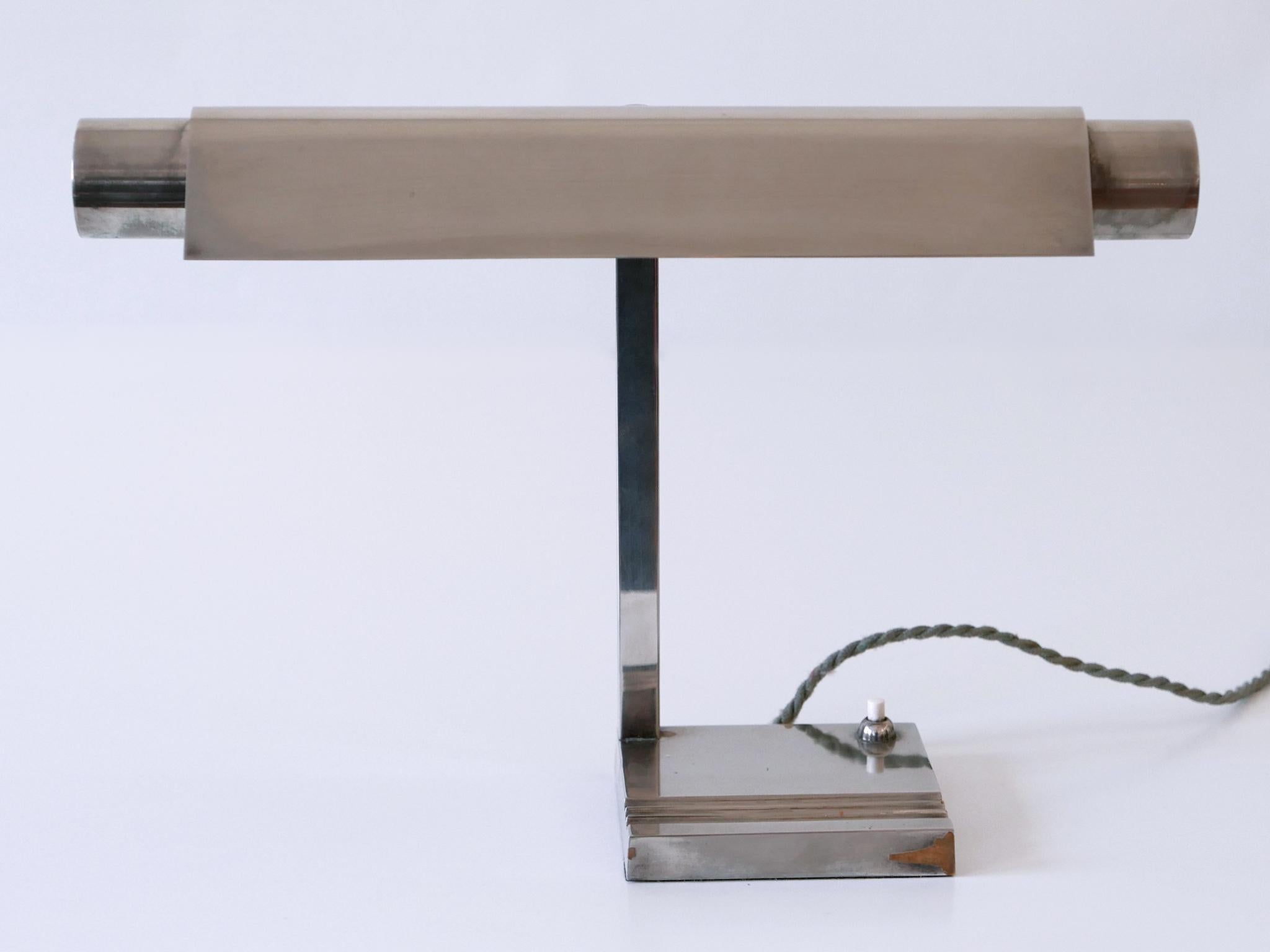 Extremely rare, minimalistic Modernist Neolux table lamp or desk light with adjustable shade. Designed and manufactured by Louis Dernier & Hamlyn Limited, England, 1930s.

Executed in nickel-plated brass, the table lamp needs 1 x Soffitte bulb, is