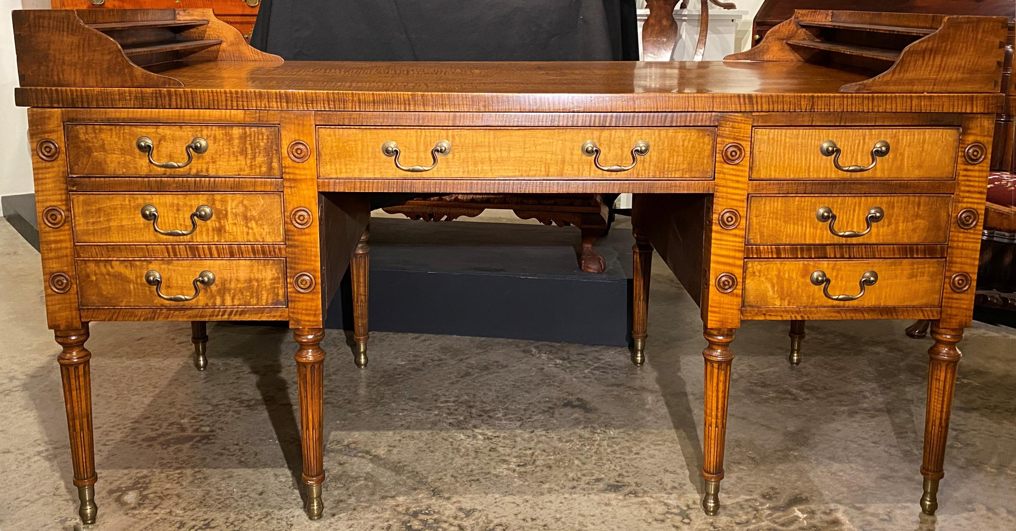 A fine quality bench made George Washington desk in tiger maple, with rectangular top featuring two removable graduated document or stationary boxes, surmounting a case with central frieze drawer flanked by three deep fitted cock beaded drawers on