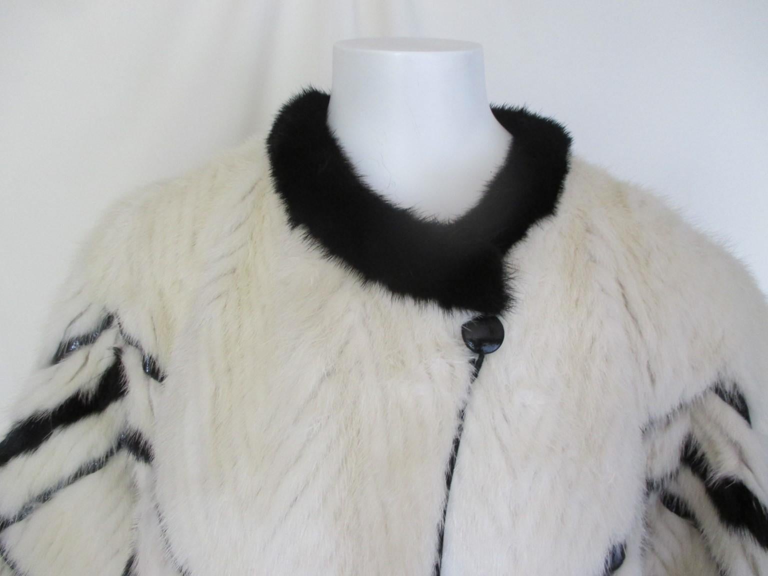 This vintage flared black & white mink coat is embroidered with black patent leather and reversible.

We offer more exclusive fur/shearling items, view our frontstore.

Details:
Reversible with silver grey leather details and has 2 black suede