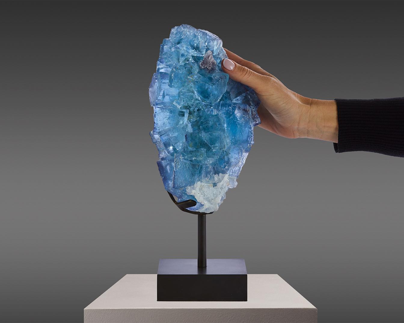 Exquisito ejemplar de fluorita azul-púrpura procedente de la renombrada
Mina La Viesca en Asturias, que cerró en 2020, fabricando piezas
como ésta cada vez más raras. El espécimen presenta tonos vibrantes
y una composición de cubos entrelazados