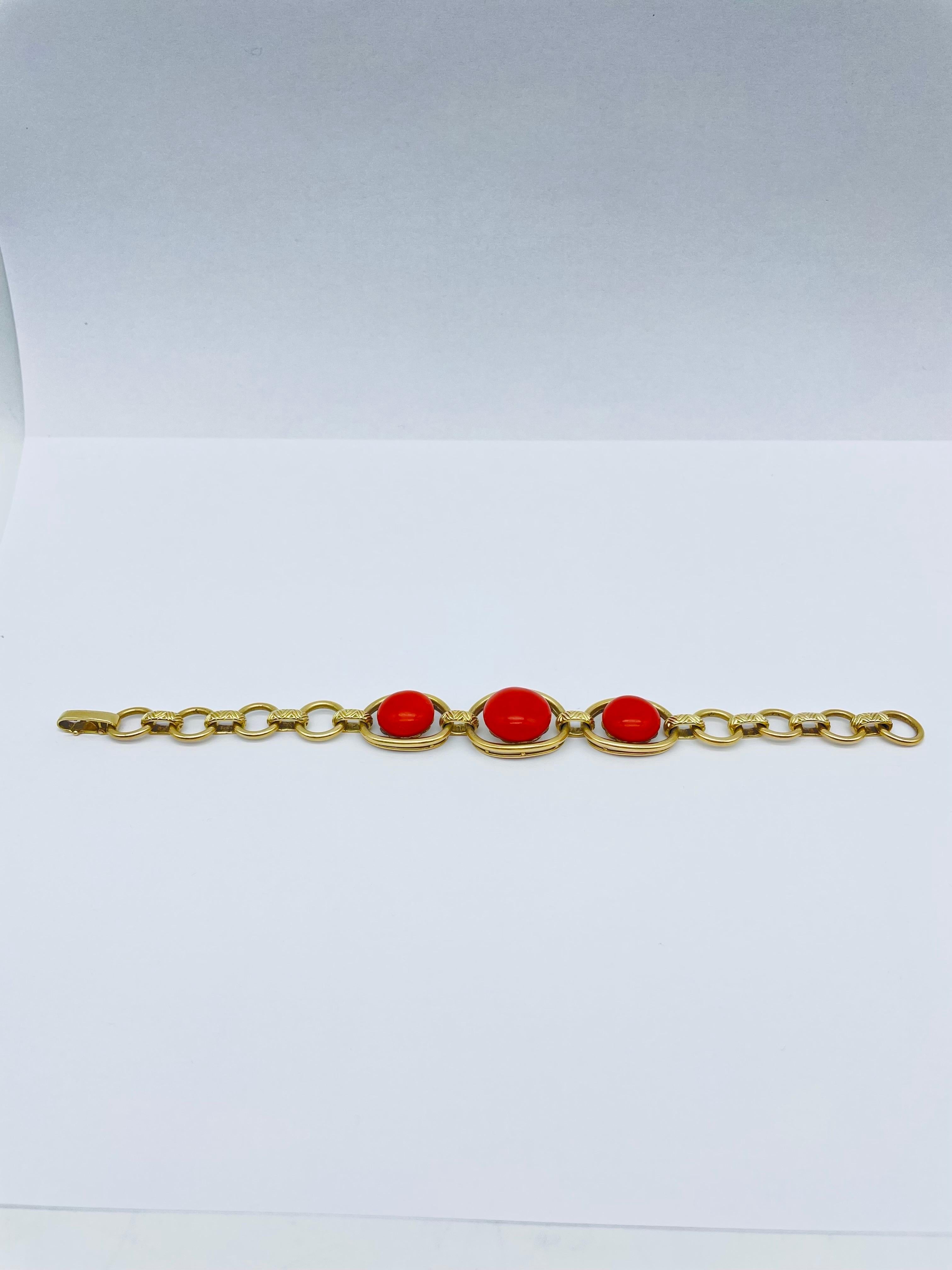 This exceptional bracelet is a true testament to the artistry and craftsmanship of fine jewelry making. Crafted from the finest 14K yellow gold, it is set with three large red coral cabochons, each one emanating a rich and vibrant hue. The cabochons