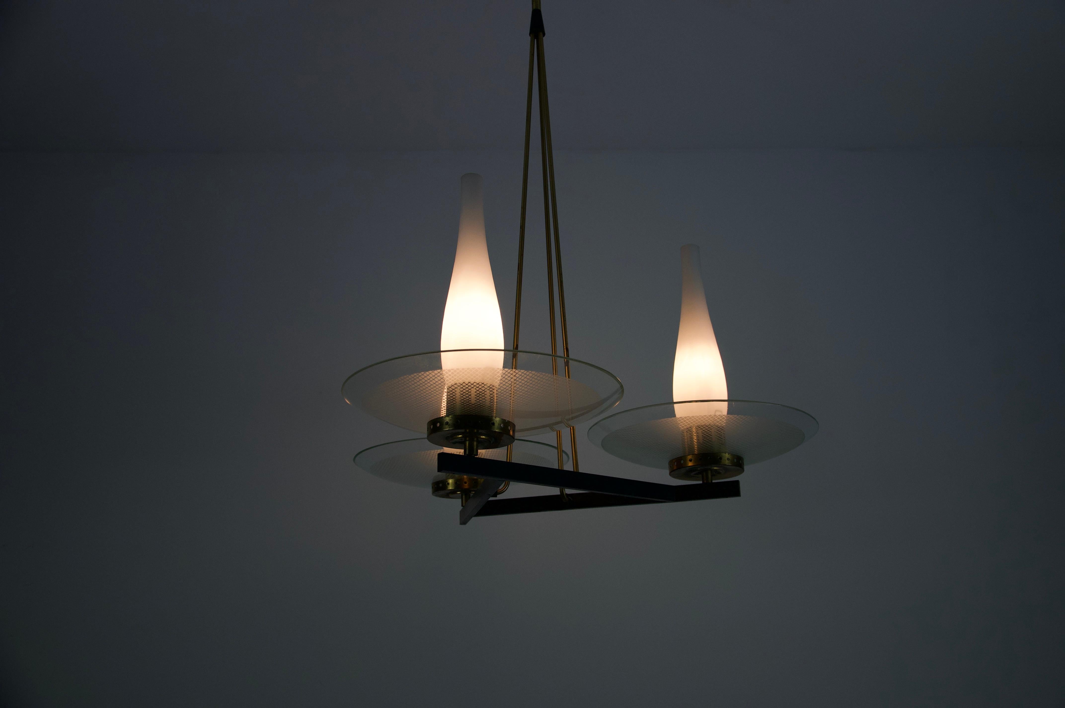 Cet exceptionnel lustre italien du milieu du siècle de Stilnovo, fabriqué dans les années 1950, est un exemple typique du langage de conception innovant et élégant de l'entreprise. Le luminaire présente une composition géométrique sophistiquée