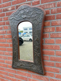 Exceptional brass-on-wood Arts & Crafts wall mirror with richly embossed foliate