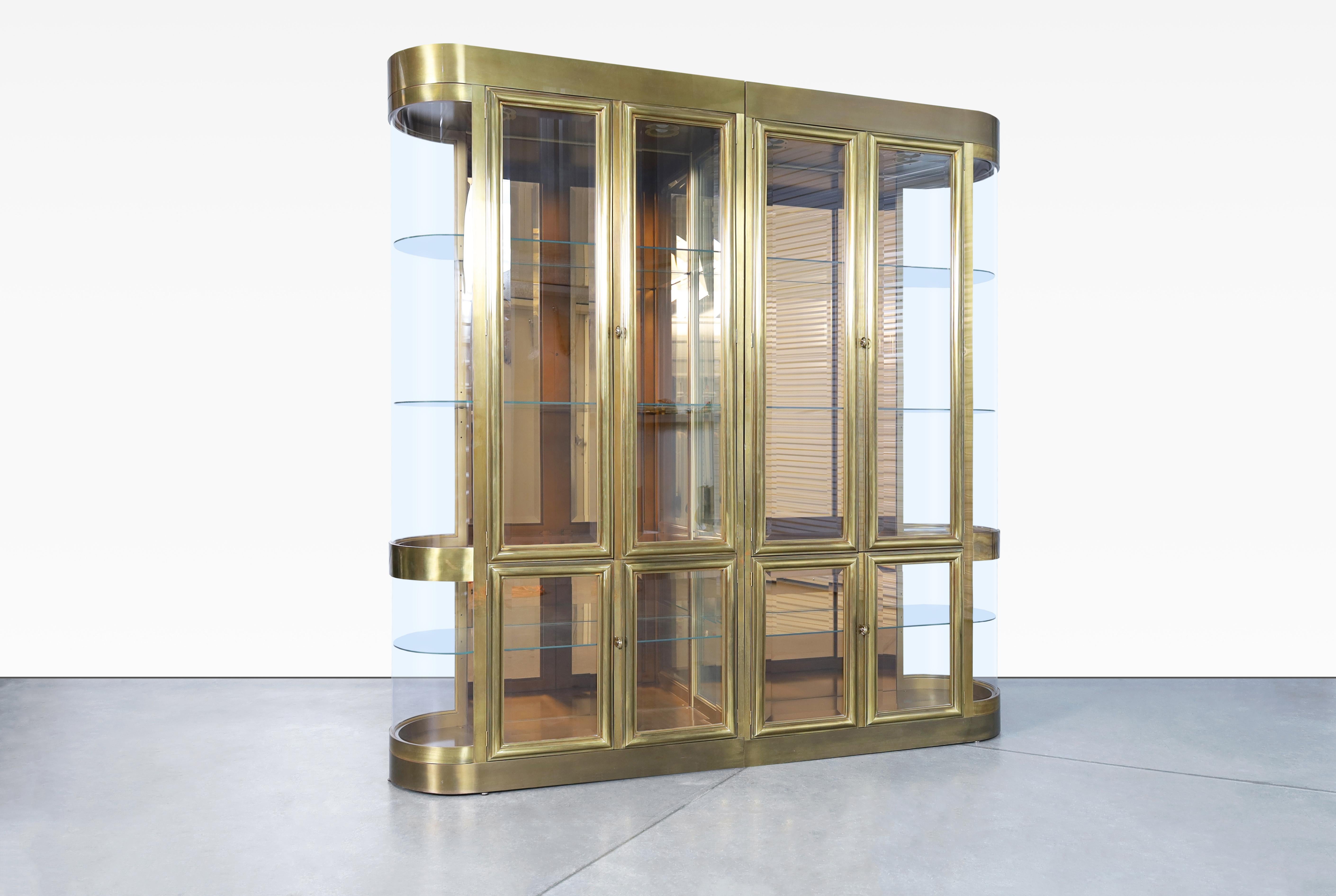 Beautiful, one-of-a-kind brass display cabinets designed by Mastercraft in the United States, circa 1970's. This stunning two-part set of handcrafted brass display cabinets invites elegance into any space. It's all in the details - large-scale and