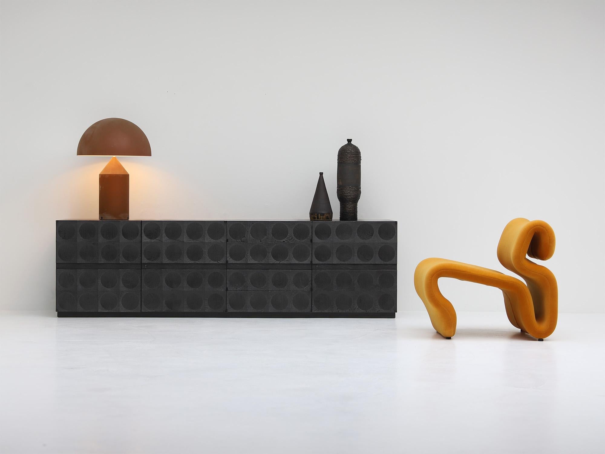 Dieses außergewöhnliche Sideboard wurde Ende der 1960er Jahre von Jean Batenburg entworfen und zeugt von der Präzision und Raffinesse der modernen belgischen Handwerkskunst.
Das aus schwarz gebeizter Eiche gefertigte Sideboard verfügt über 4