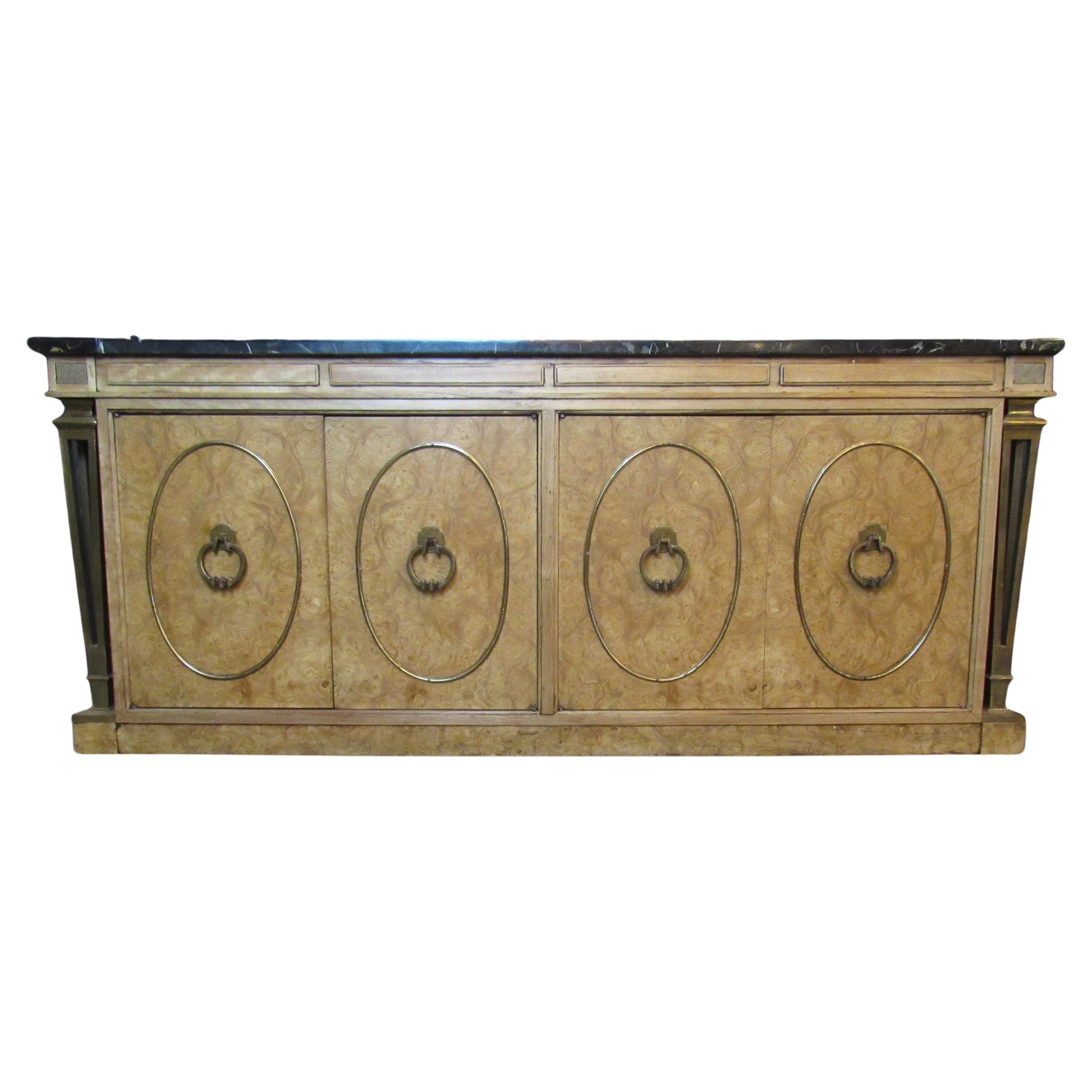Bring home the timeless elegance of Michigan's Mastercraft Furniture with this genuinely stunning credenza made of marble, brass, and burl. Seamlessly blending the classic elements of Mid-Century Modern and Hollywood Regency design, while concealing