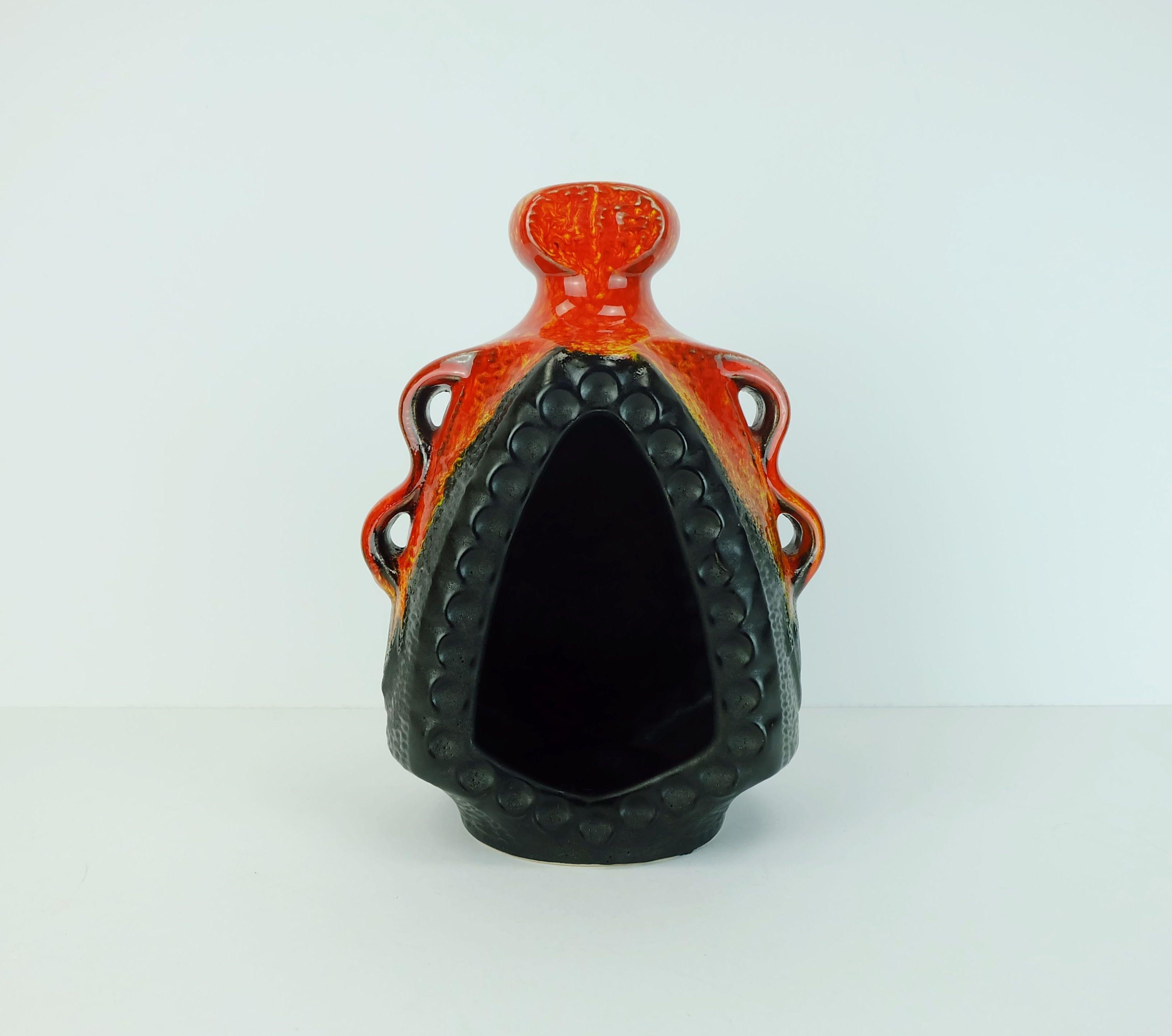Grande candeliere prodotto da Bay Keramik in Germania Ovest negli anni '60-'70. Nero opaco e smalto lucido rosso e arancione. La candela viene inserita nel recipiente. Può essere appoggiato o appeso alla parete. Marcato sul fondo 