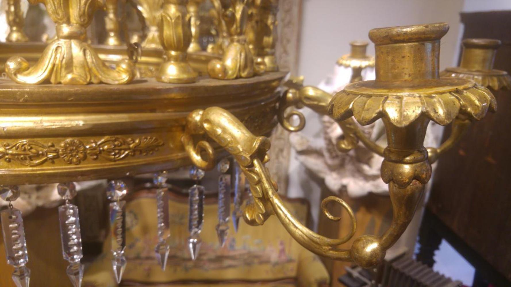 Exceptionnelle lampe en bois sculpté et doré de l'époque de Carlos IV, 
avec un anneau unique et un chandelier à 20 lumières ; dix verticales et dix enroulements de feuillage. 
Il est vendu dans son état actuel ; avec ses chaînes et sa couronne de