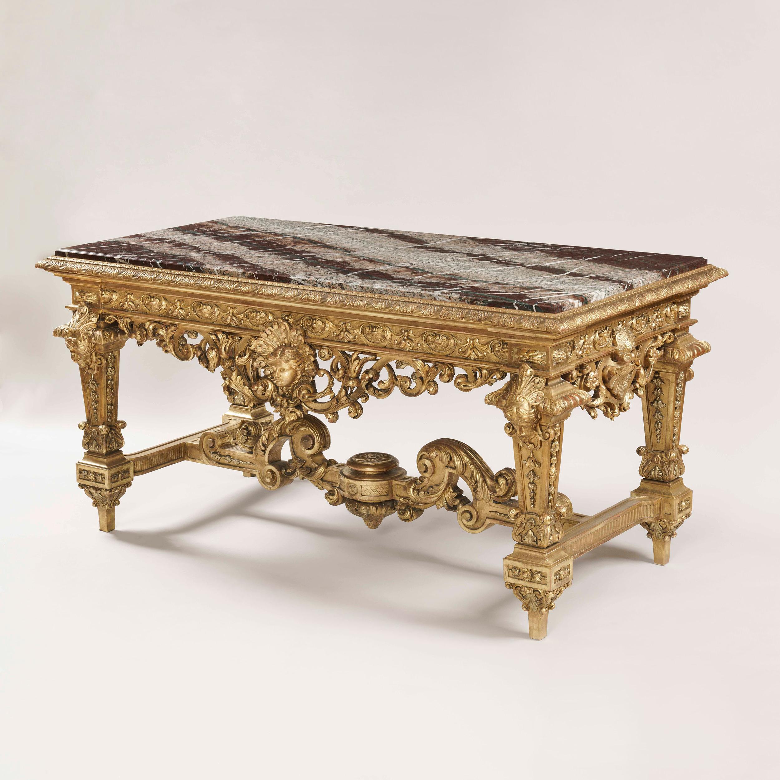 An exceptional giltwood table de Milieu
in the Louis XIV style

A true carver's delight, the giltwood center table of rectangular form supported on four baluster form legs interjoined by a stretcher, the free-standing table incorporating pierced