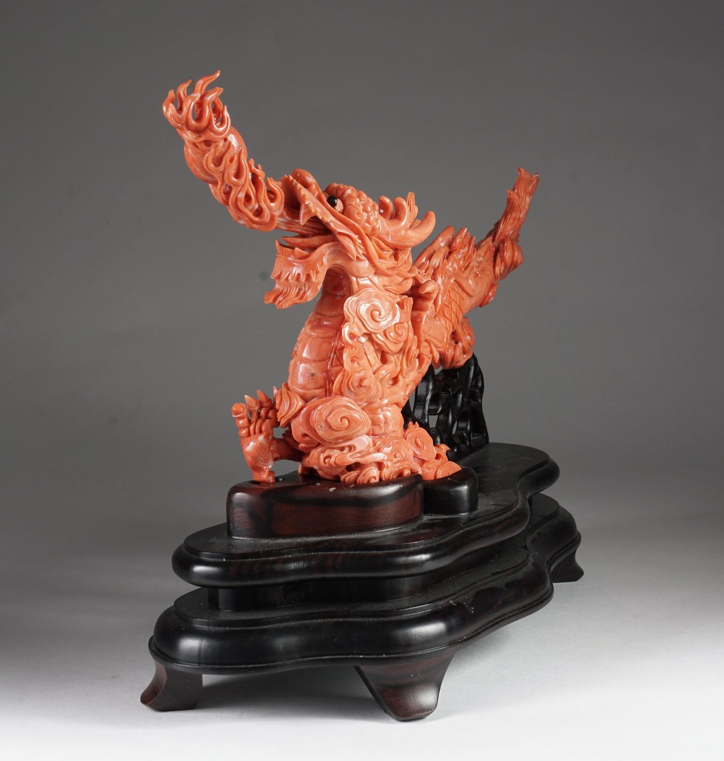 An exceptional Chinese carved coral dragon with fire, Qing dynasty.

Very finely carved. With original wooden base.

Measures: Coral: 7.5