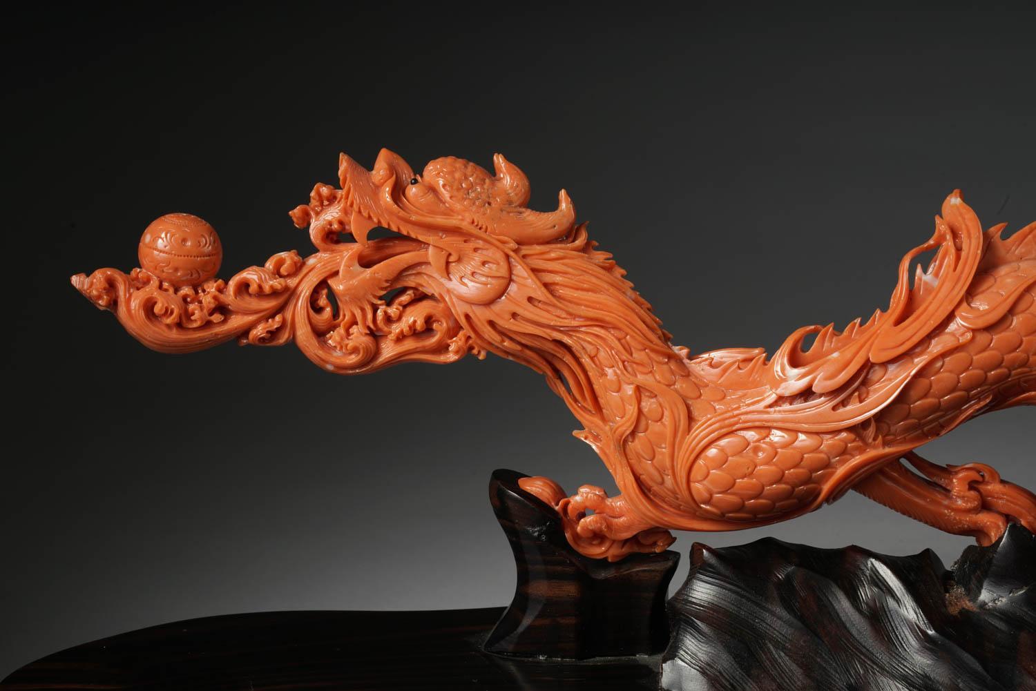 An exceptional Chinese carved coral dragon with fire, Qing dynasty.

Very finely carved. With original wooden base.

Measures: Coral 5