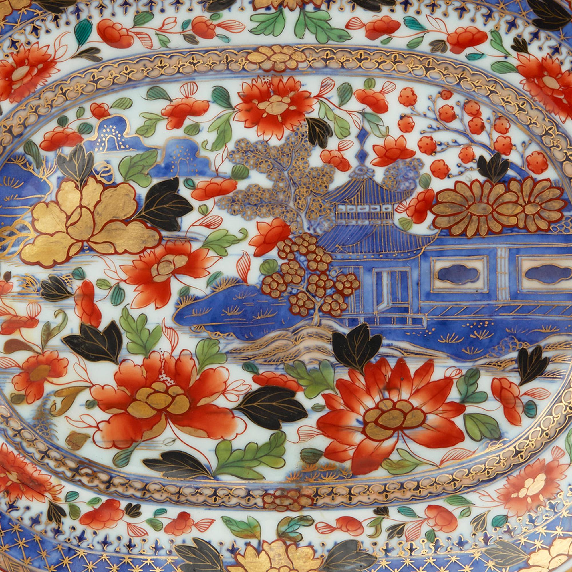 A stunning and exceptional antique Chinese qianlong porcelain serving platter decorated in under glaze blue with a pagoda in a rocky river landscape and clobbered (over painted) in London with Imari style flowers in red, green and gilding. The