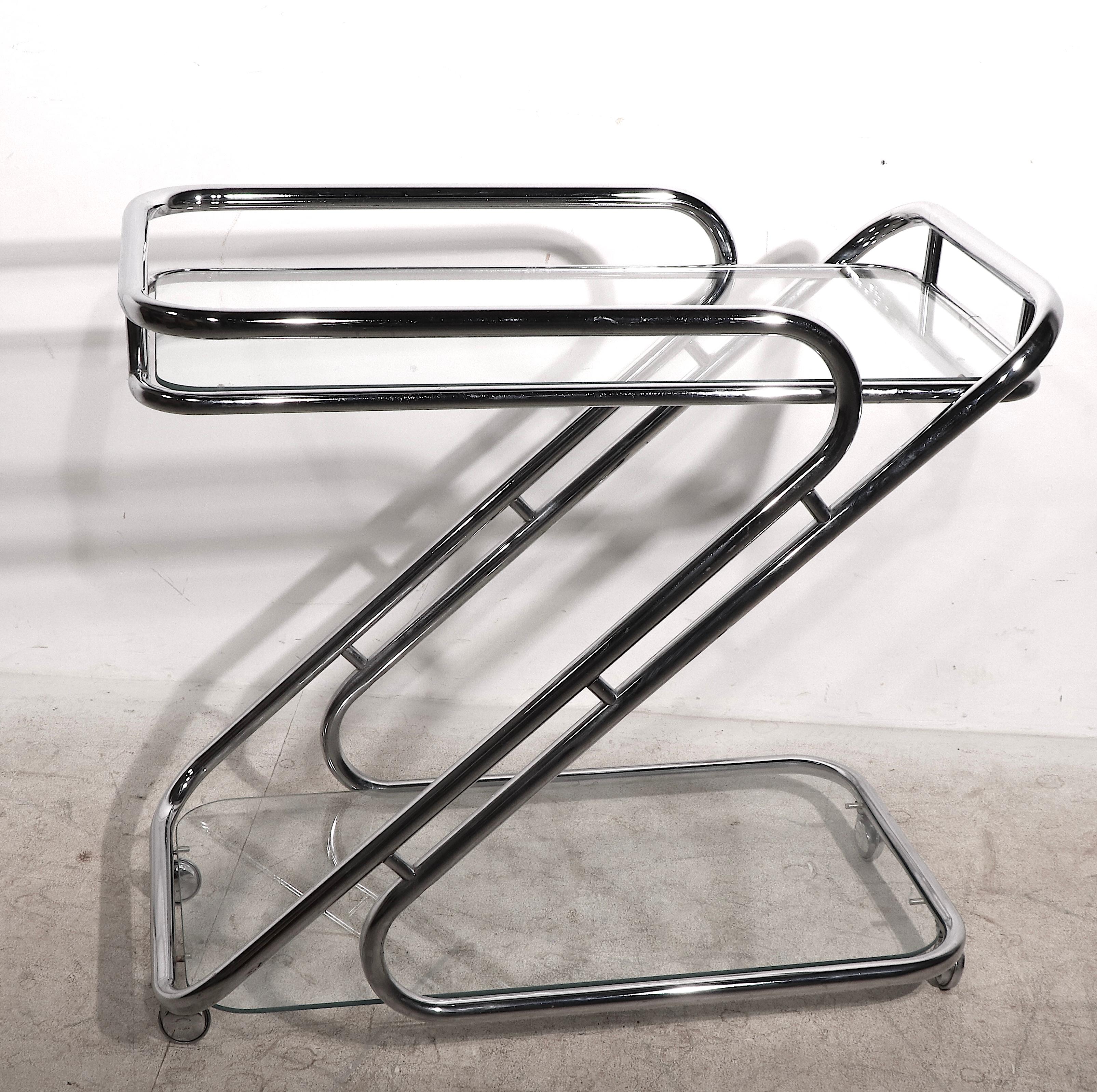 Exceptional Hollywood Regency style tubular chrome and glass two tier rolling bar cart, in the style of Milo Baughman. This example is unusually large, it is very well crafted and in very fine, original, clean and ready to use condition.
 Measures: