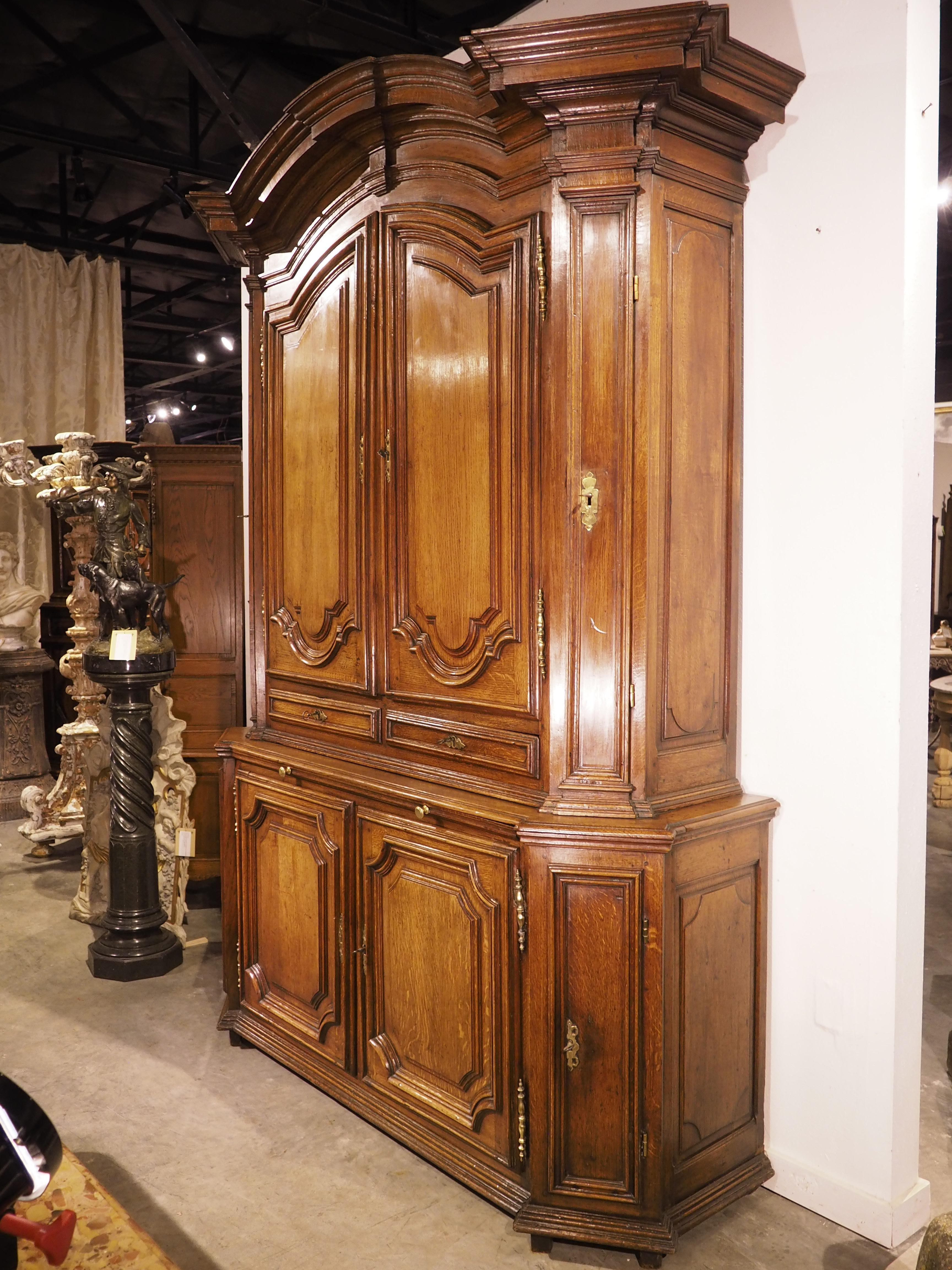 Intagliato a mano in Francia, intorno al 1700, questo eccezionale buffet deux corps in rovere offre un ampio spazio di archiviazione con otto ante, due cassetti e un vassoio estraibile. Tutte le porte sono dotate di serrature funzionali, azionate da
