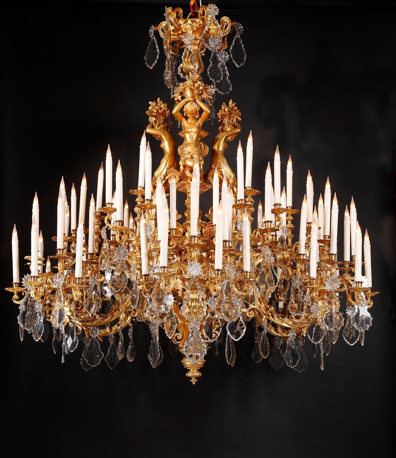 This very important 96-lights chandelier made entirely in chiseled and gilded bronze in the Renaissance style, is composed at the lower part of six large sets of ten light-arms, adorned with Bacchus masks, scalloped acanthuses, pearls and “cuir