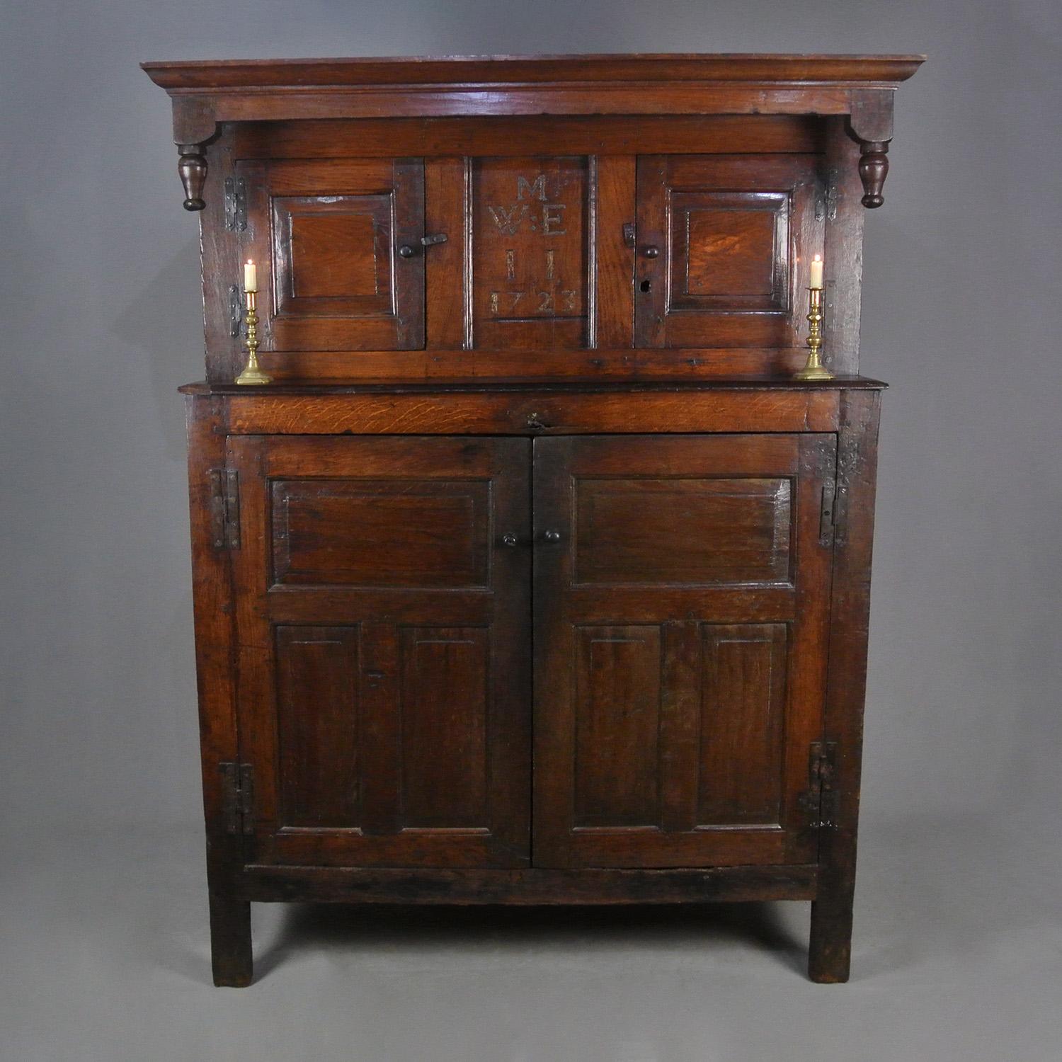 This superior quality and very beautiful English oak press cupboard is of tall and slender proportions and is within its 300th anniversary year.

The front panel is carved with the letters M (married) over W:E over I and I – William and Eliza Issacs