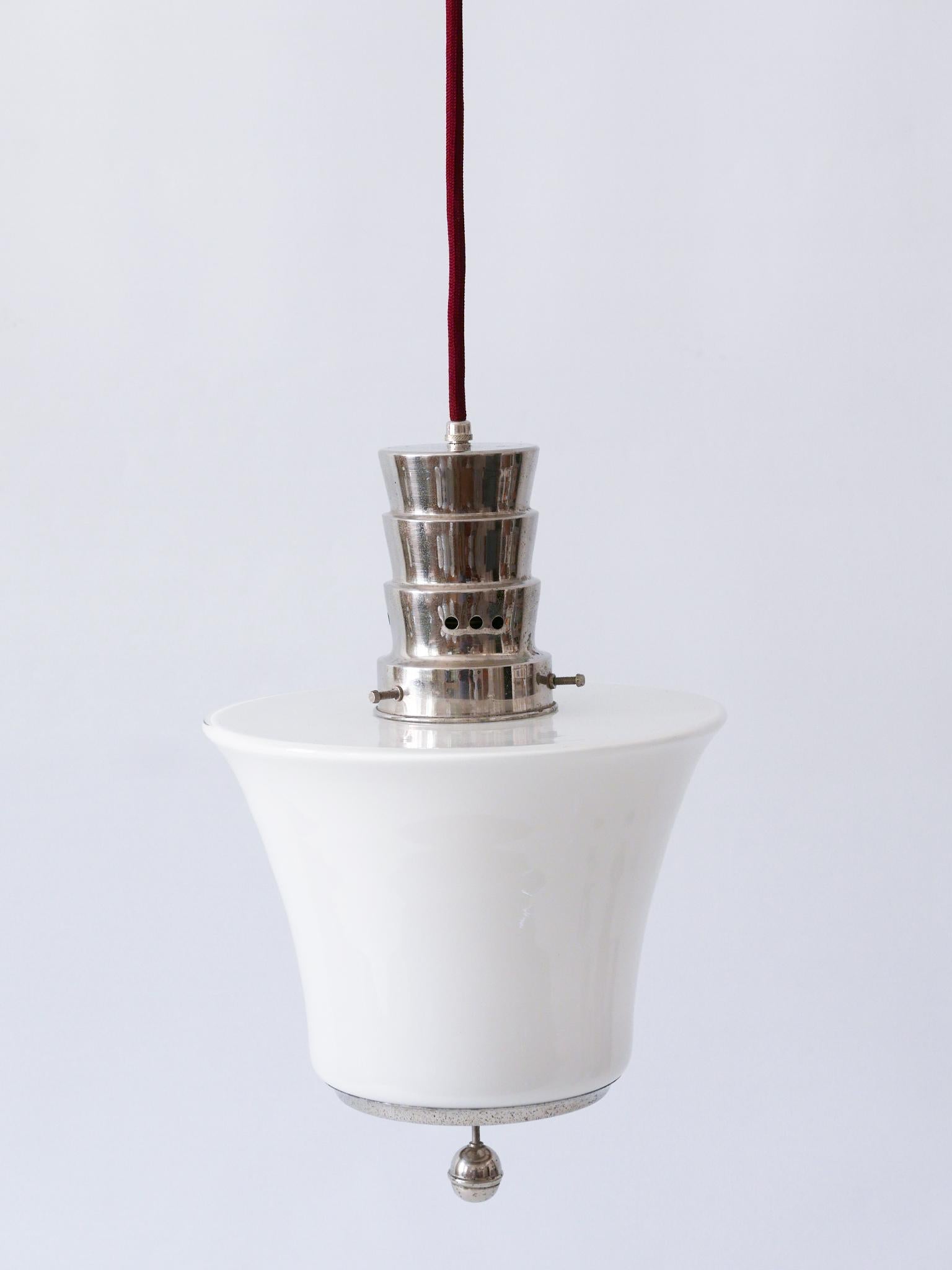 Extremely rare and minimalistic Bauhaus / Art Deco pendant lamp or hanging light. Manufactured by Dr. Twerdy Leuchten, 1920s, Germany. Makers mark to the top: Dr. Twerdy Original.

Executed in nickel-plated brass and opaline glass, the lamp needs