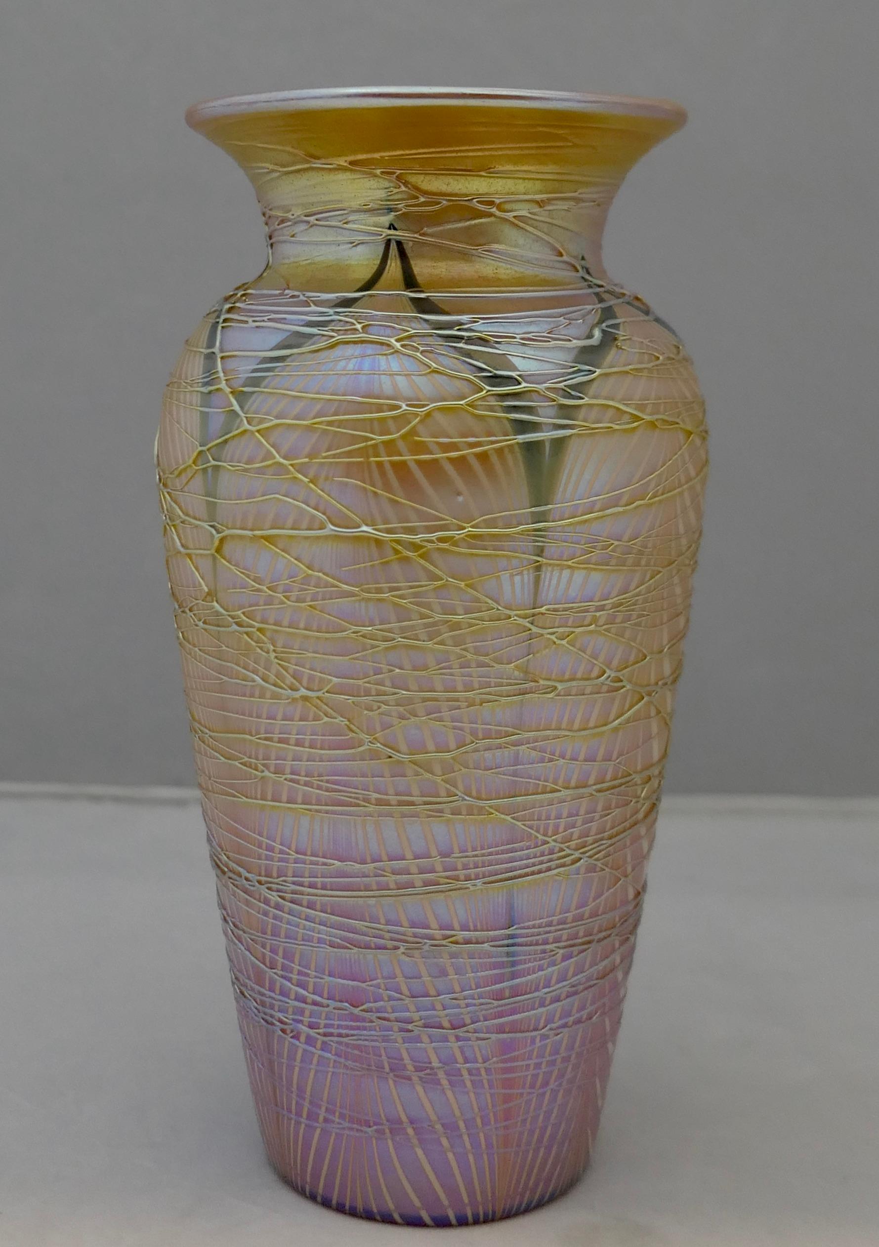 Questo splendido vaso d'epoca in vetro artistico è stato realizzato dal Durand Art Glass Shop all'inizio del XX secolo. Ha una splendida iridescenza dorata decorata con cinque ampie piume stilizzate verticali che circondano il vaso dalla base al