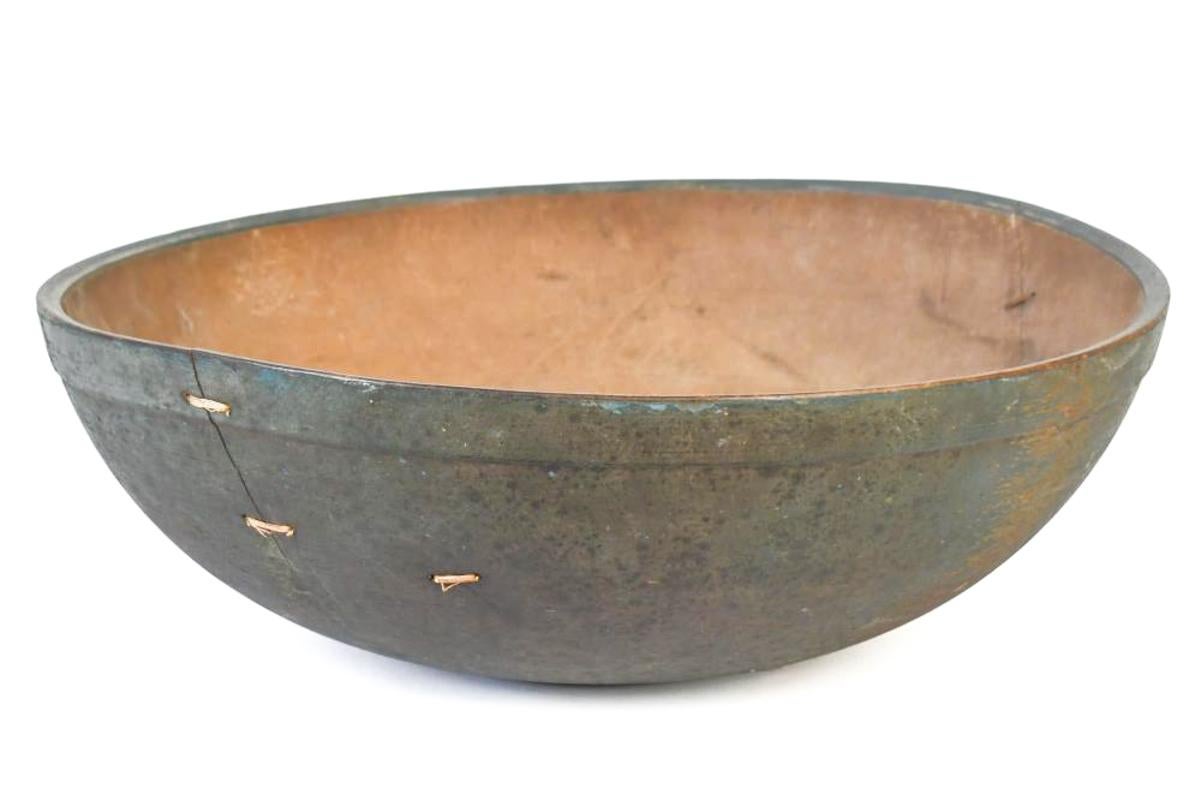 A rare early 19th century New England wooden chopping bowl in original blue-green paint with beautiful stitched repairs and rich patina.
An extraordinary example of early American utilitarian craftsmanship, this rare New England hardwood chopping