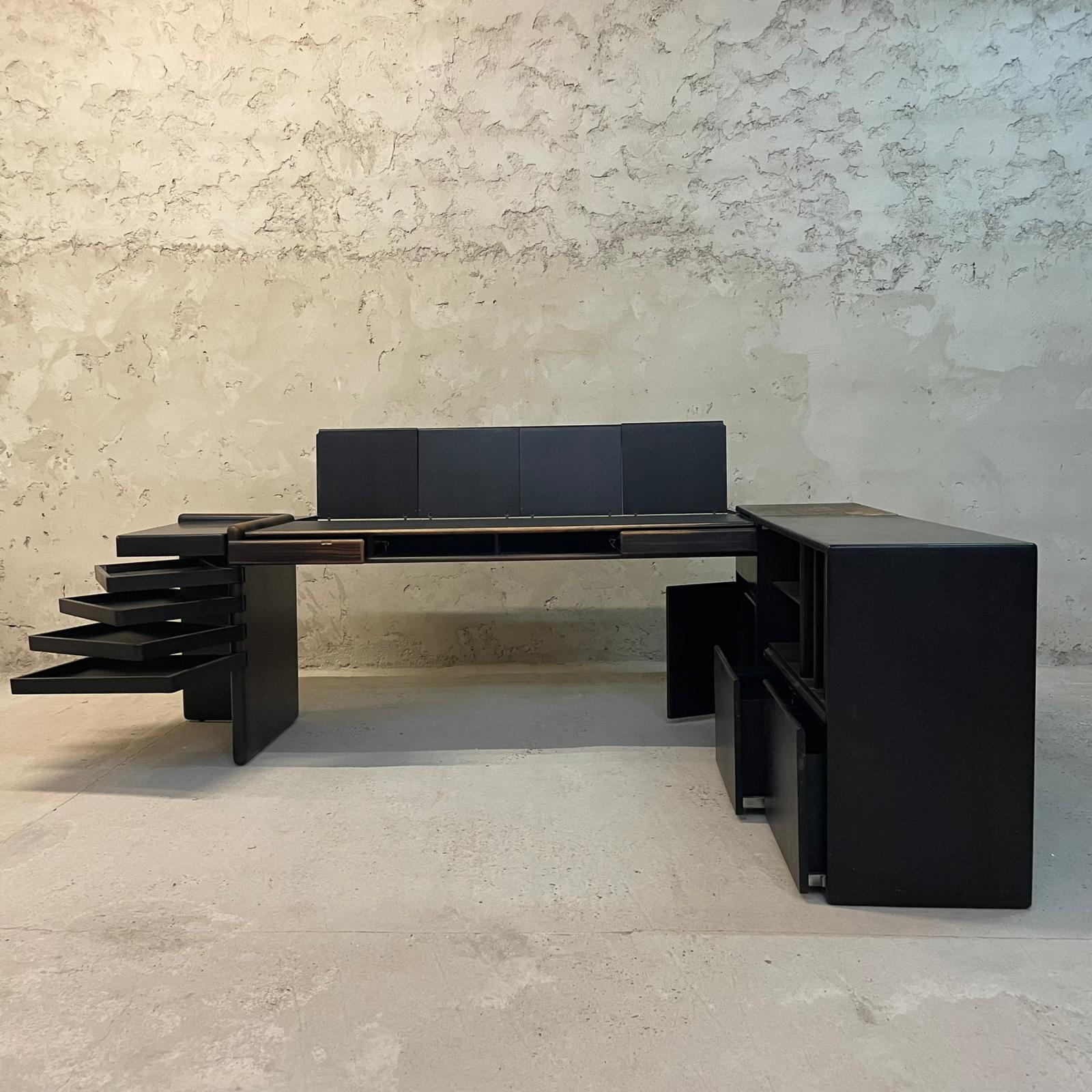 Executive and exceptionally rare ebony executive desk designed by Fabio Lenci for Bernini in 1974. Four compass trays, two front drawers, four folding compartments with plastic trays each, magazine rack, trash can, removable ashtray cast iron, side