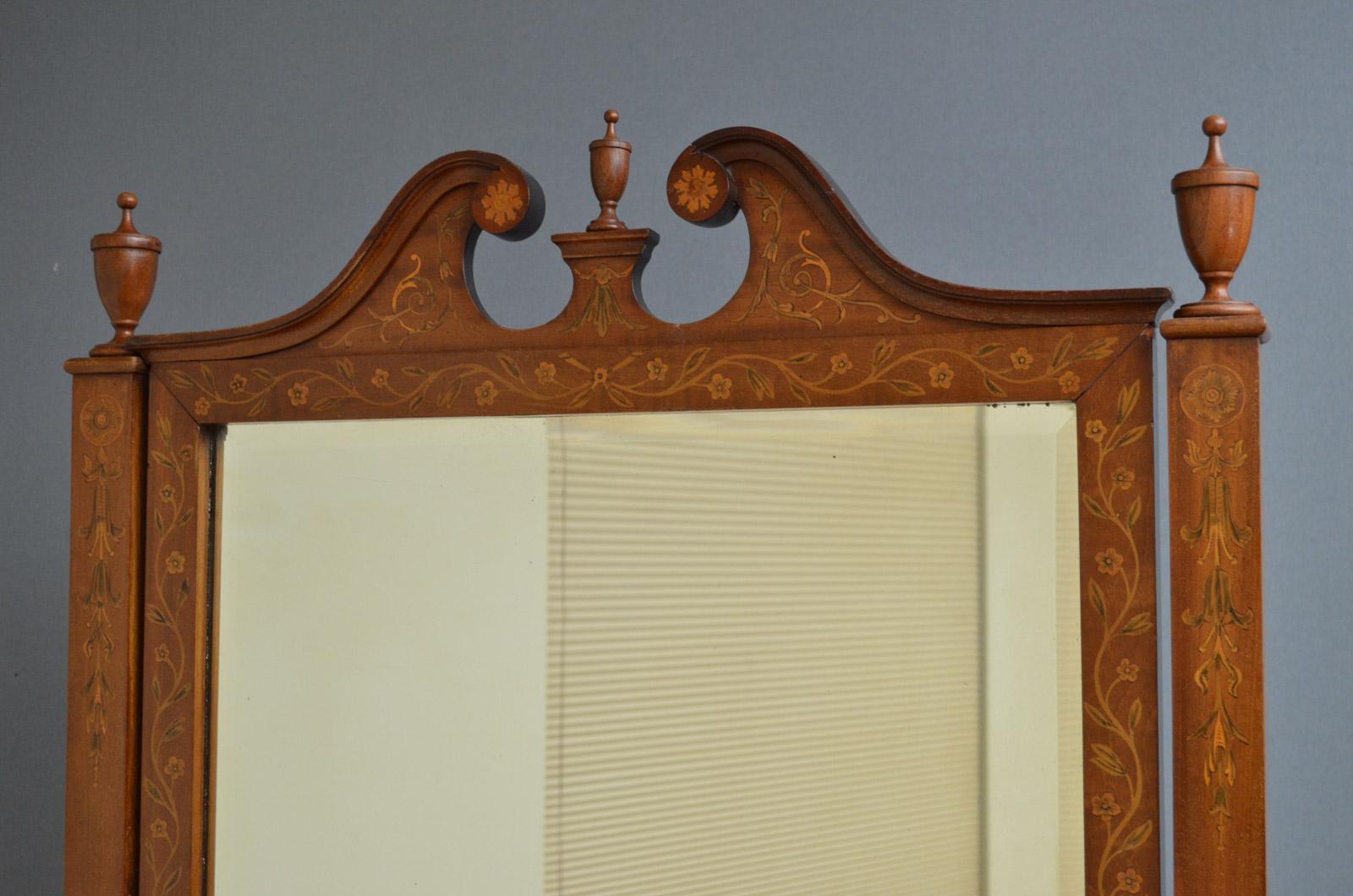 Sn3616, exceptional Edwardian, mahogany and inlaid cheval mirror, having inlaid pediment with finials above original mirror plate in finely inlaid frame and uprights, standing on downswept legs terminating in original brass castors. This fantastic