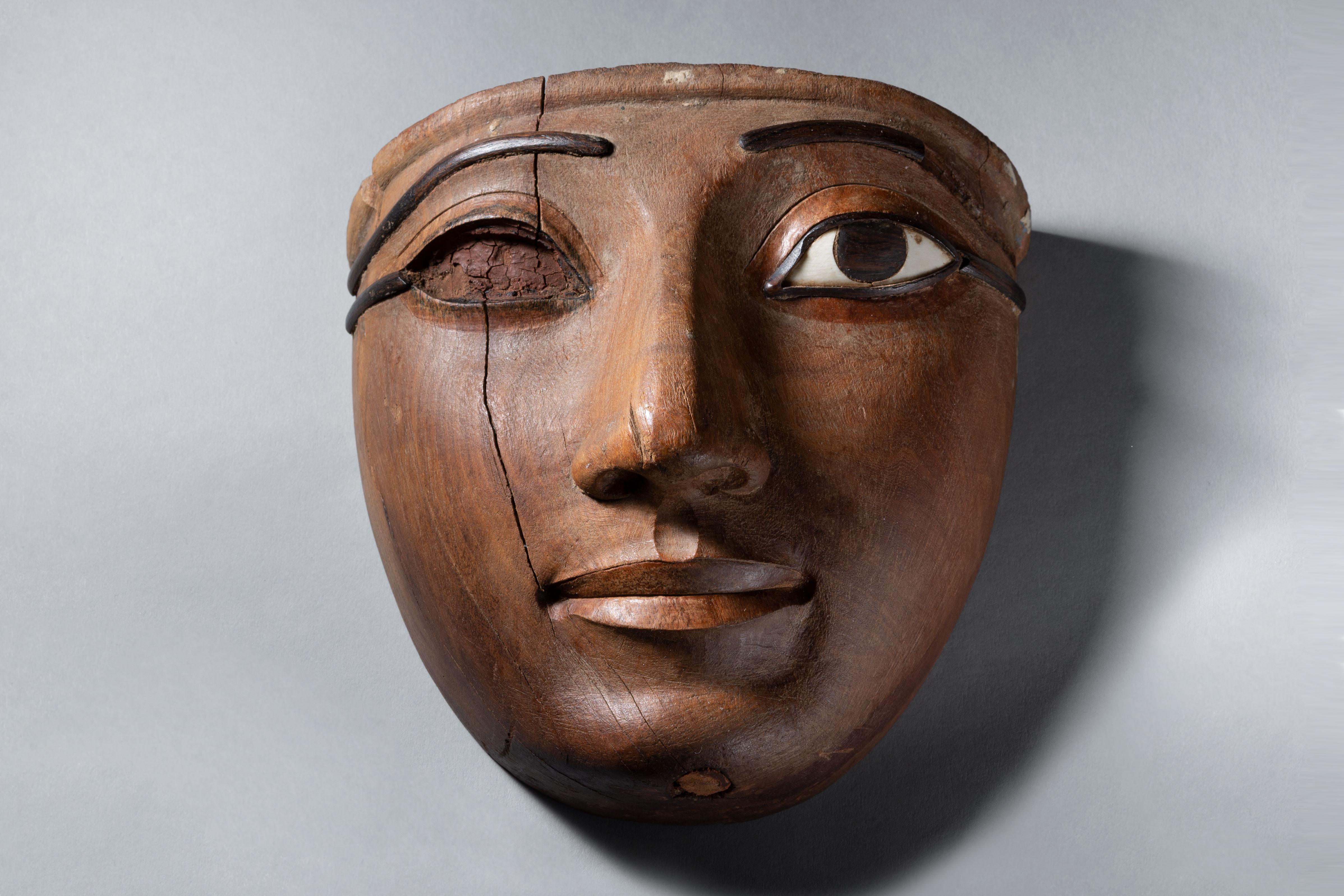 Exceptionally Fine Wooden Sarcophagus Mask
Third Intermediate Period,  21st Dynasty, circa 1069-945 BC.
Acacia wood, rosewood, hippopotamus ivory

Masterfully carved from a single piece of fine-grained hardwood, the present mask is characteristic of