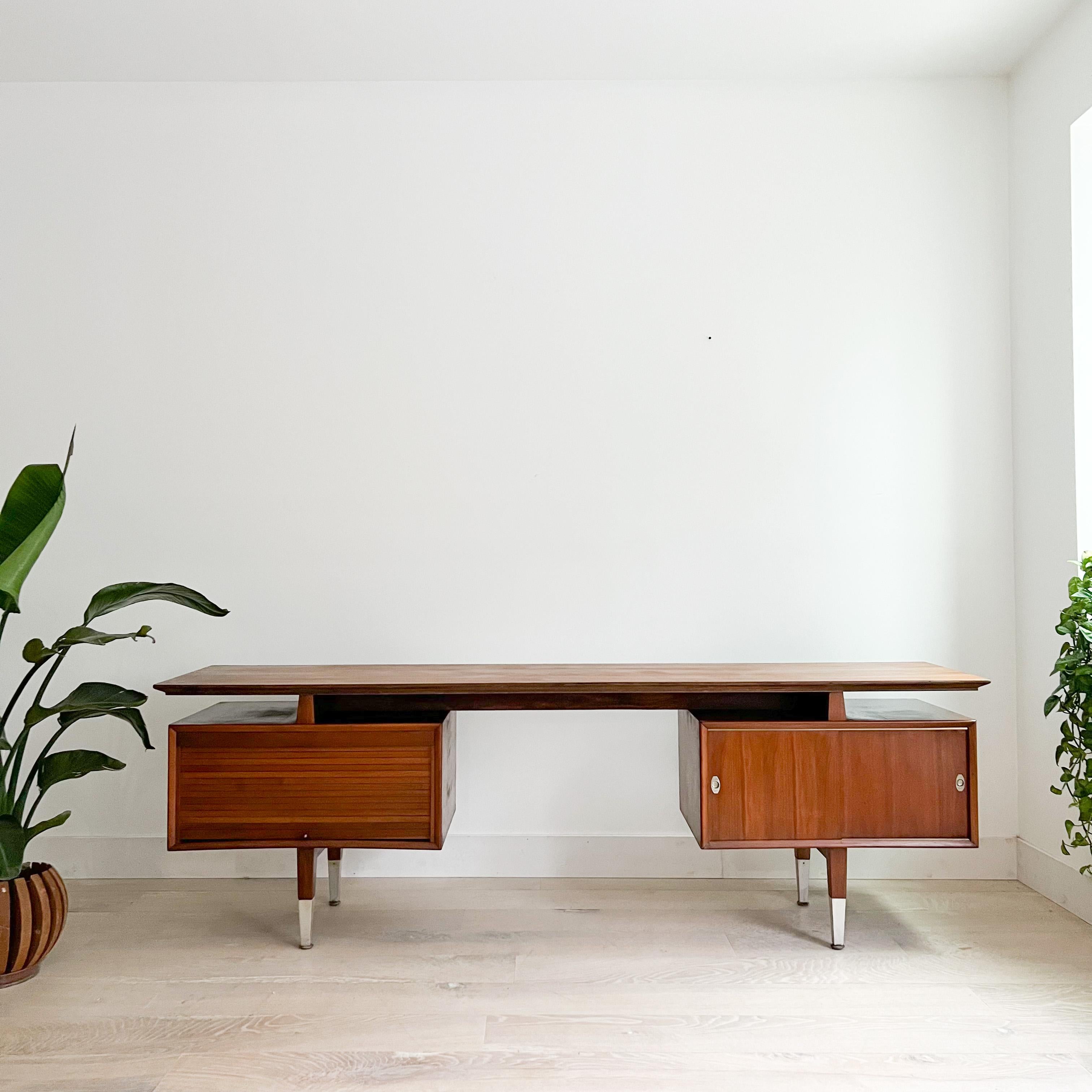 Step into the world of mid-century design with this exceptional mid-century modern walnut desk. Crafted with meticulous attention to detail, it embodies the enduring charm of mid-century aesthetics.

This desk is not just a piece of furniture; it's