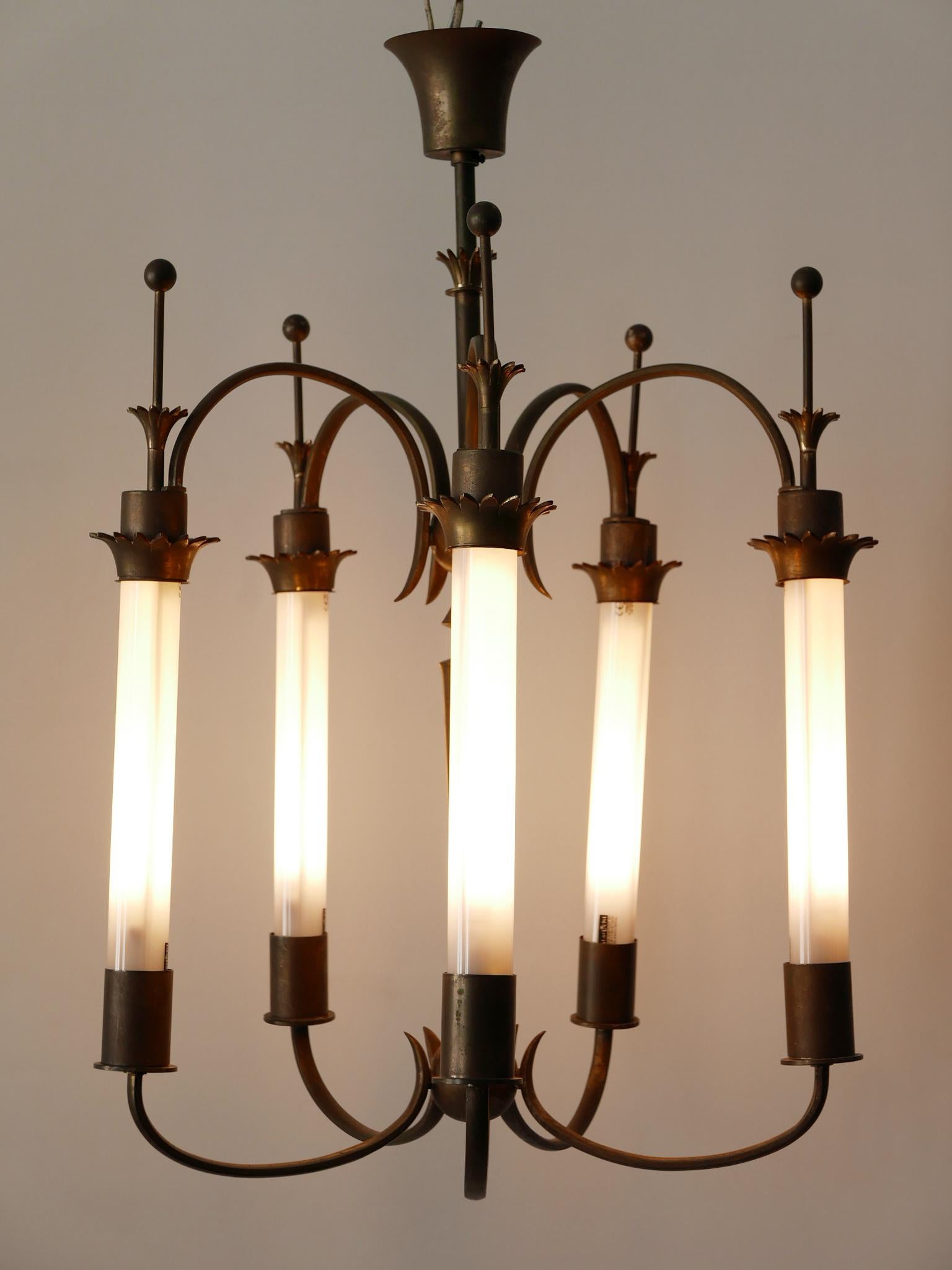 Exceptional and elegant Art Deco chandelier or ceiling lamp. Designed and manufactured probably in Germany, 1930s.

Executed in brass, the chandelier needs 5 x Soffitte S19 bulbs, is wired and in working condition. It runs both on 110/230 Volt.