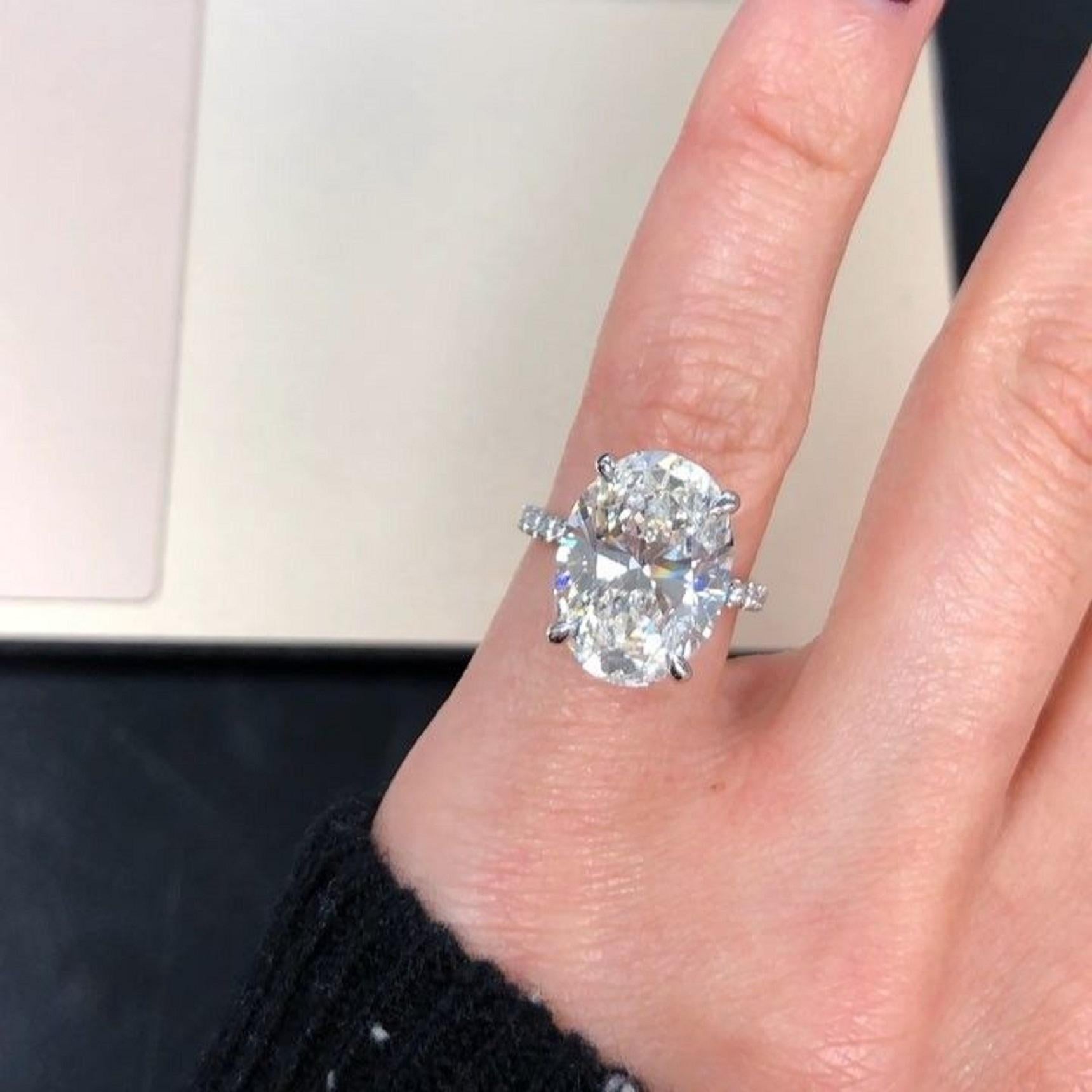 This elegant engagement ring features a breathtaking 5.04 carat oval cut diamond as its centerpiece, certified by the GIA for its exceptional quality. 
Set in 18K white gold, the diamond is complemented by a delicate pavé setting along the band,