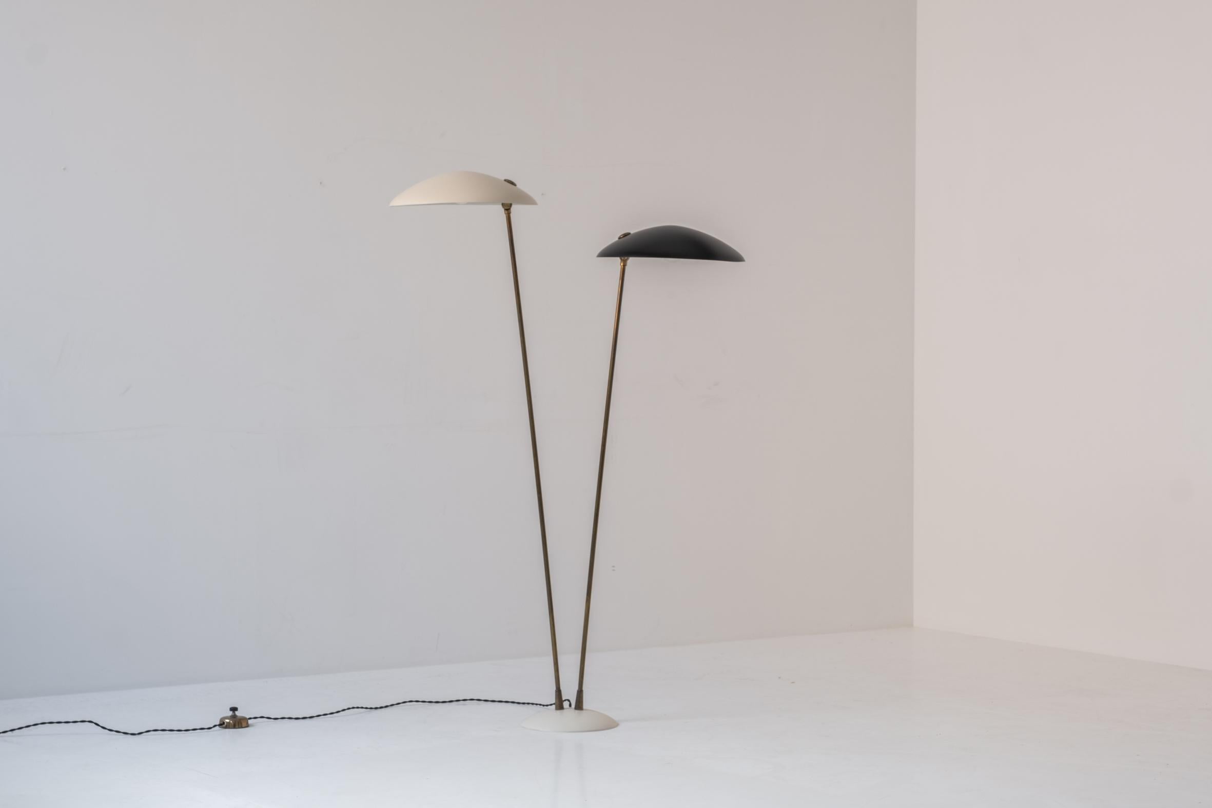 Admire this exceptional floor lamp designed and manufactured during the 1960s. This floor lamp features two beige and black lacquered shades mounted on brass stems. The lampshades are professionally re-lacquered (same colour as the original colour