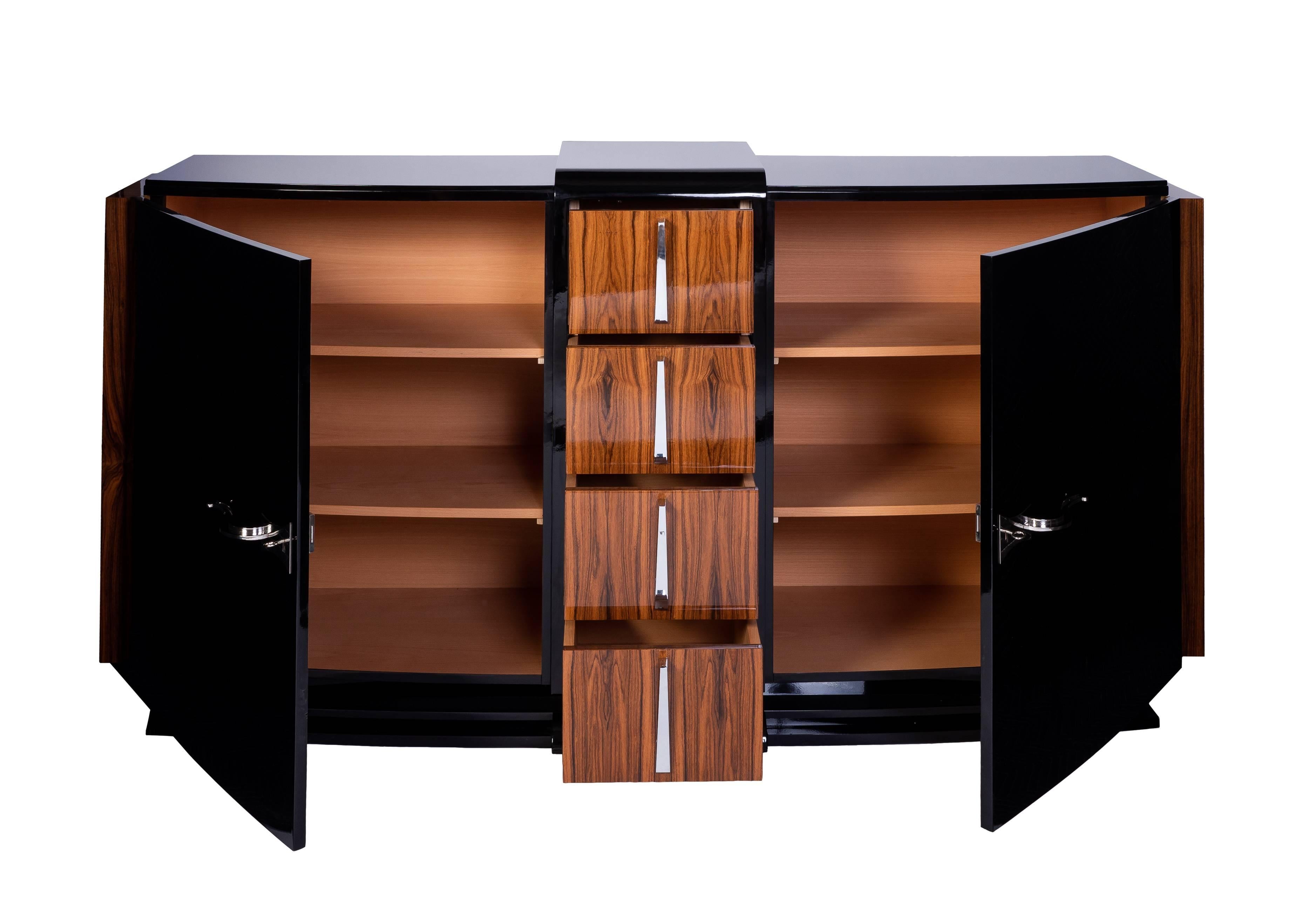 This exceptional Art Deco sideboard features a curved front with burled palisander detailing, two swing doors, four drawers and chrome platted fixtures. The pieces has been finished in a high gloss black lacquer.