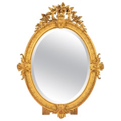 Eccezionale specchio ovale francese in legno dorato di epoca Napoleone III con vetro al mercurio originale