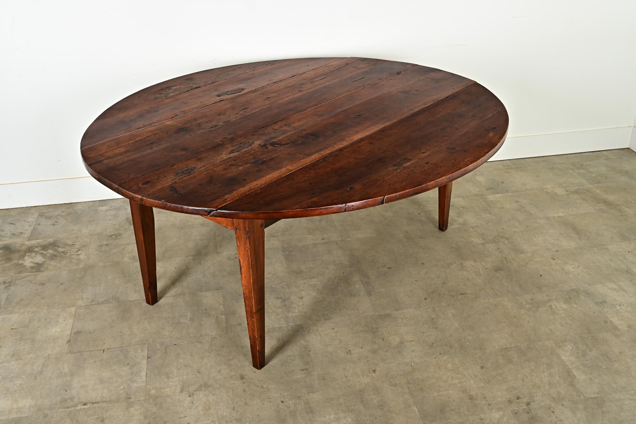 This stunning oval drop leaf dining table was made of beautiful solid walnut circa 1820 in France. The walnut has wonderful and thoughtfully done honest repairs throughout the top which give the table a unique and one of a kind presence. The apron