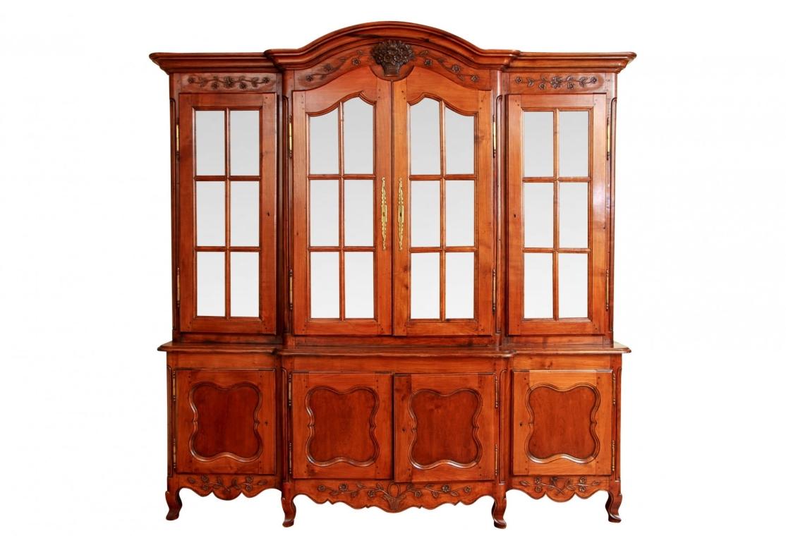 Un notevole mobile in stile provinciale francese con molti dettagli floreali intagliati. Con un piano con cornice a cavetto e arco centrale sopra un cesto floreale centrale intagliato e tralci fioriti ai lati. Il fronte sagomato e sporgente con