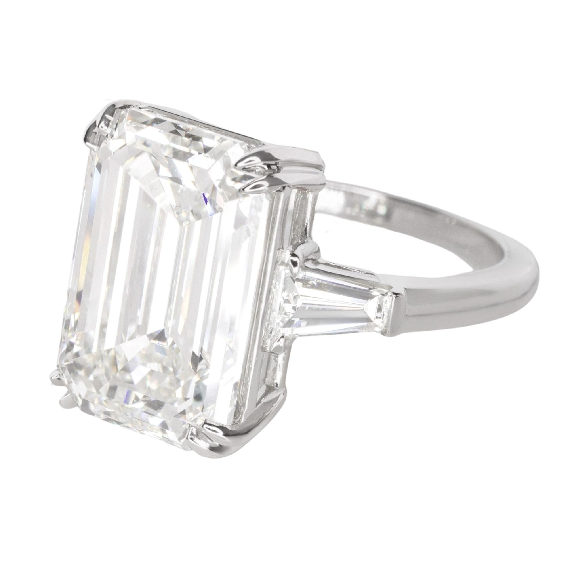 Gorgeous and utterly classic vintage engagement ring combines eye catching impressive sparkle with an eternally stylish design. The 3 carat emerald cut center diamond is bright white, completely loop clean, and sparkles with gorgeous brilliance!