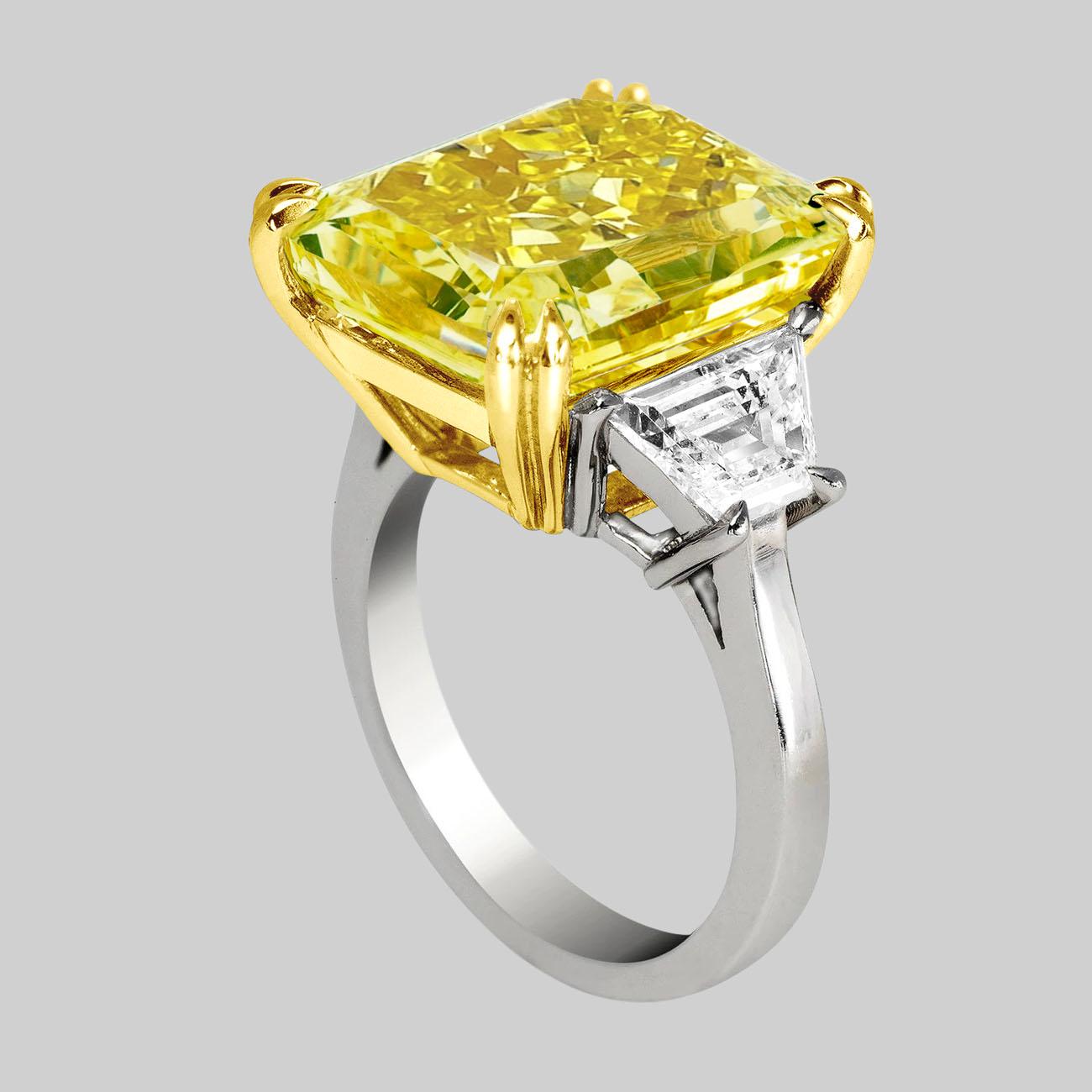 This beautiful statement ring features a 23 carat Fancy VIVID Yellow Brilliant  Cushion Cut Diamond flanked with trapezoid cut white diamonds 

See pictures for details. (see certificate picture for more detailed center stone information)

For this