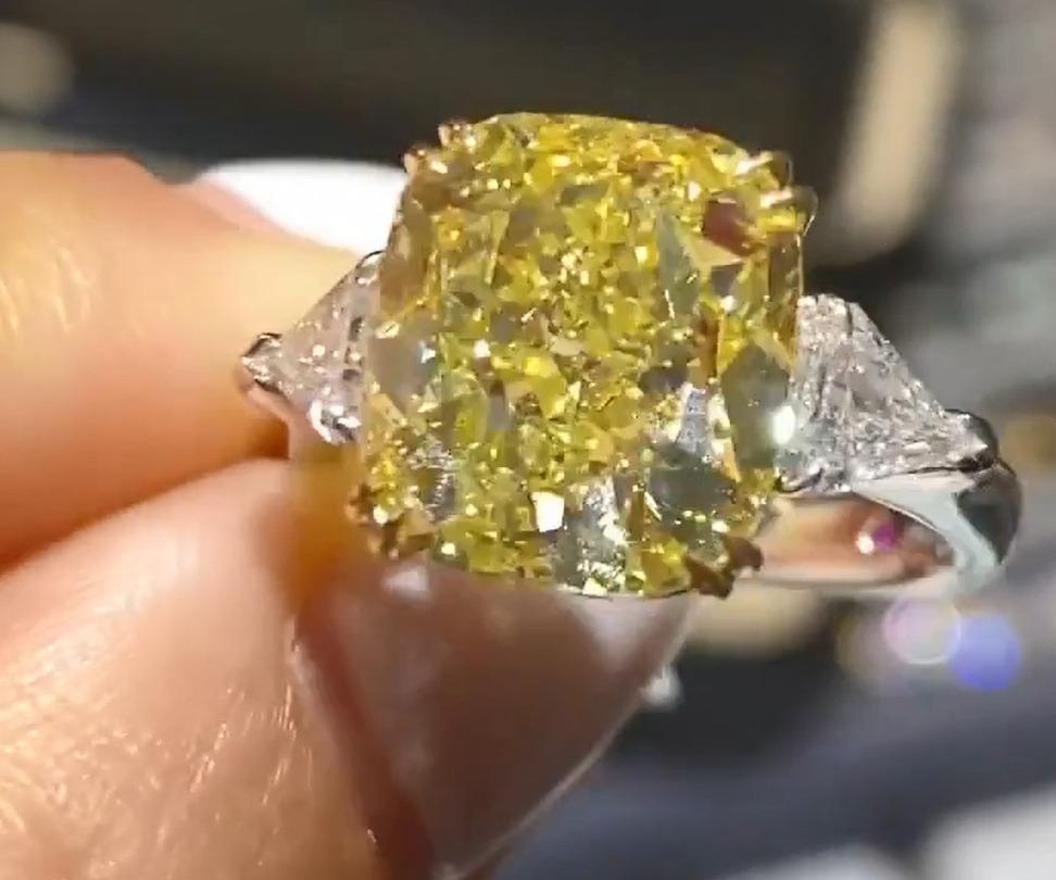 Exquise bague en diamant jaune fantaisie de 4.10 carats, certifiée par le GIA, présentant un poli et une symétrie excellents et ne présentant aucune fluorescence.

Le diamant a été rehaussé de deux diamants de taille trillion et serti dans de l'or