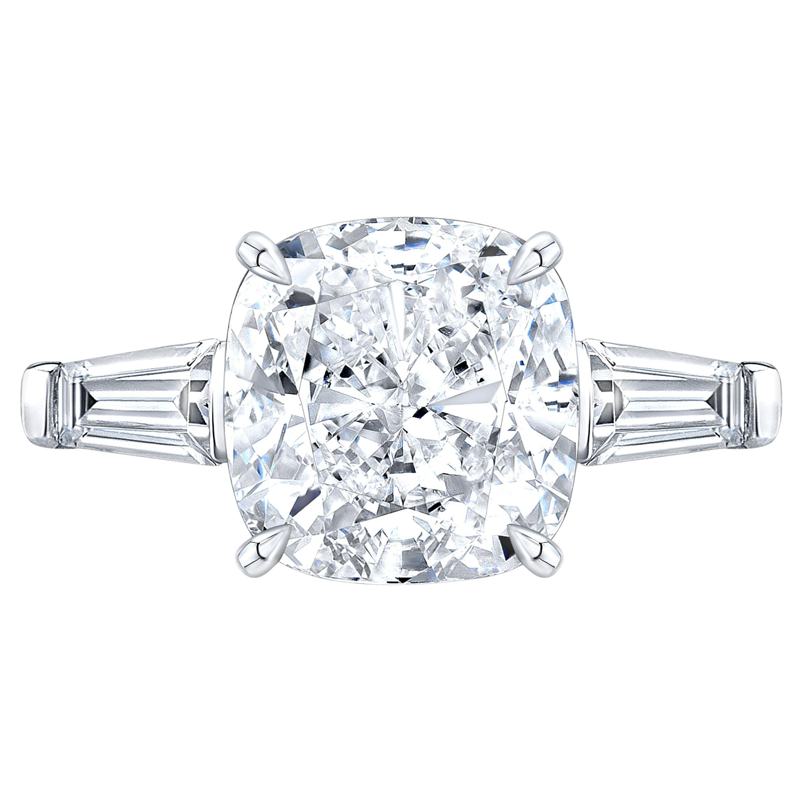 Questo squisito anello è caratterizzato da un diamante taglio cuscino da 5,08 carati, certificato GIA per la sua notevole qualità. 
Incastonato in oro bianco 18 carati, il diamante è affiancato da diamanti baguette affusolati, creando un design