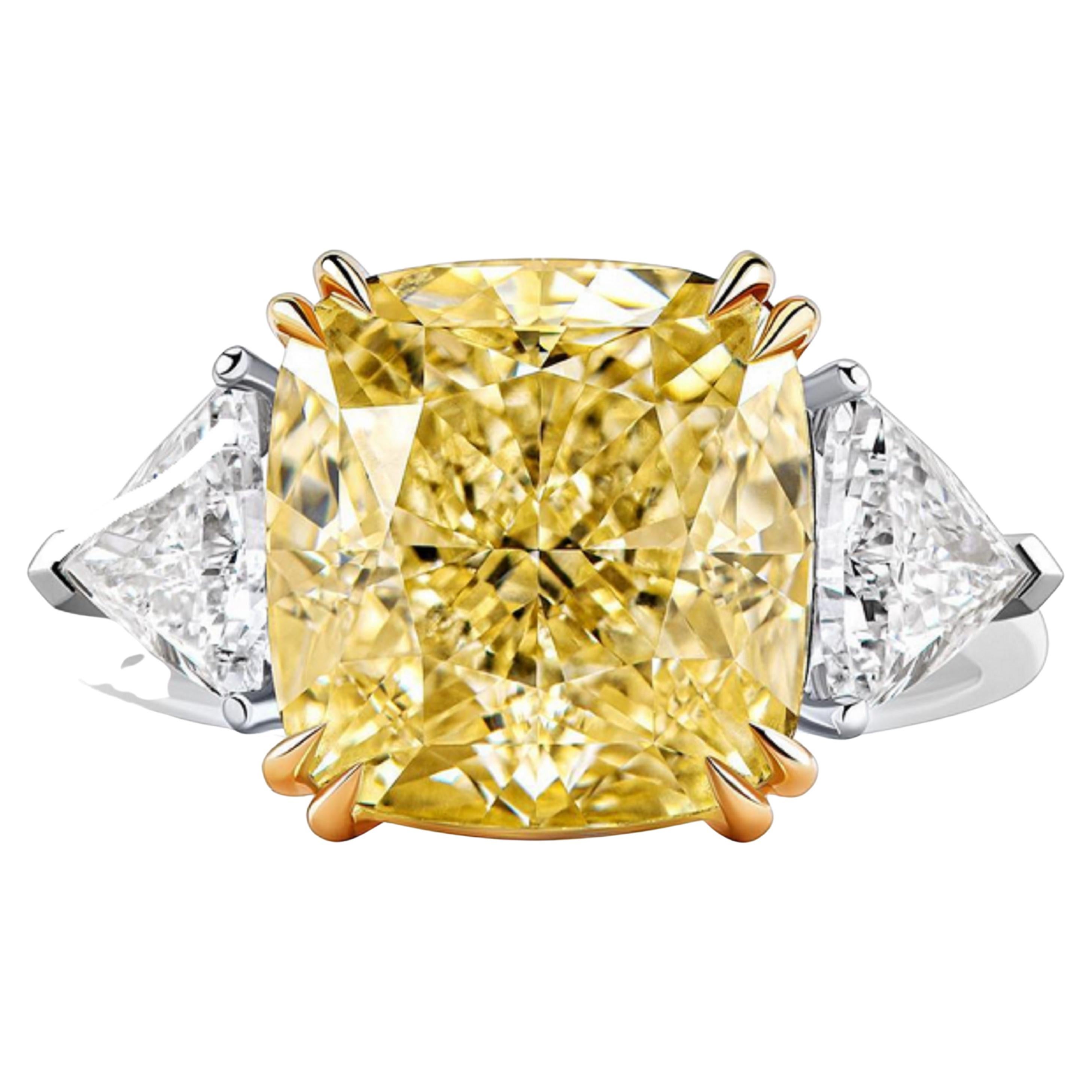 Introducing the exquisite GIA Certified 5.15 Carat Fancy Yellow Diamond Ring, embellished with two trillions on each side. This exceptional ring showcases a stunning fancy yellow diamond, certified by the esteemed Gemological Institute of America