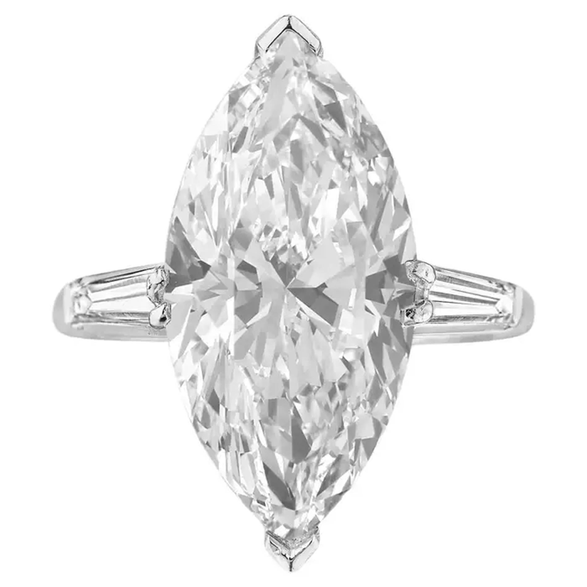 This exceptional ring features a stunning centerpiece—a GIA certified 6.11 carat marquise-cut diamond of unparalleled beauty and brilliance. Set in enduring platinum, the diamond is flanked by two tapered baguette diamonds on either side, adding a
