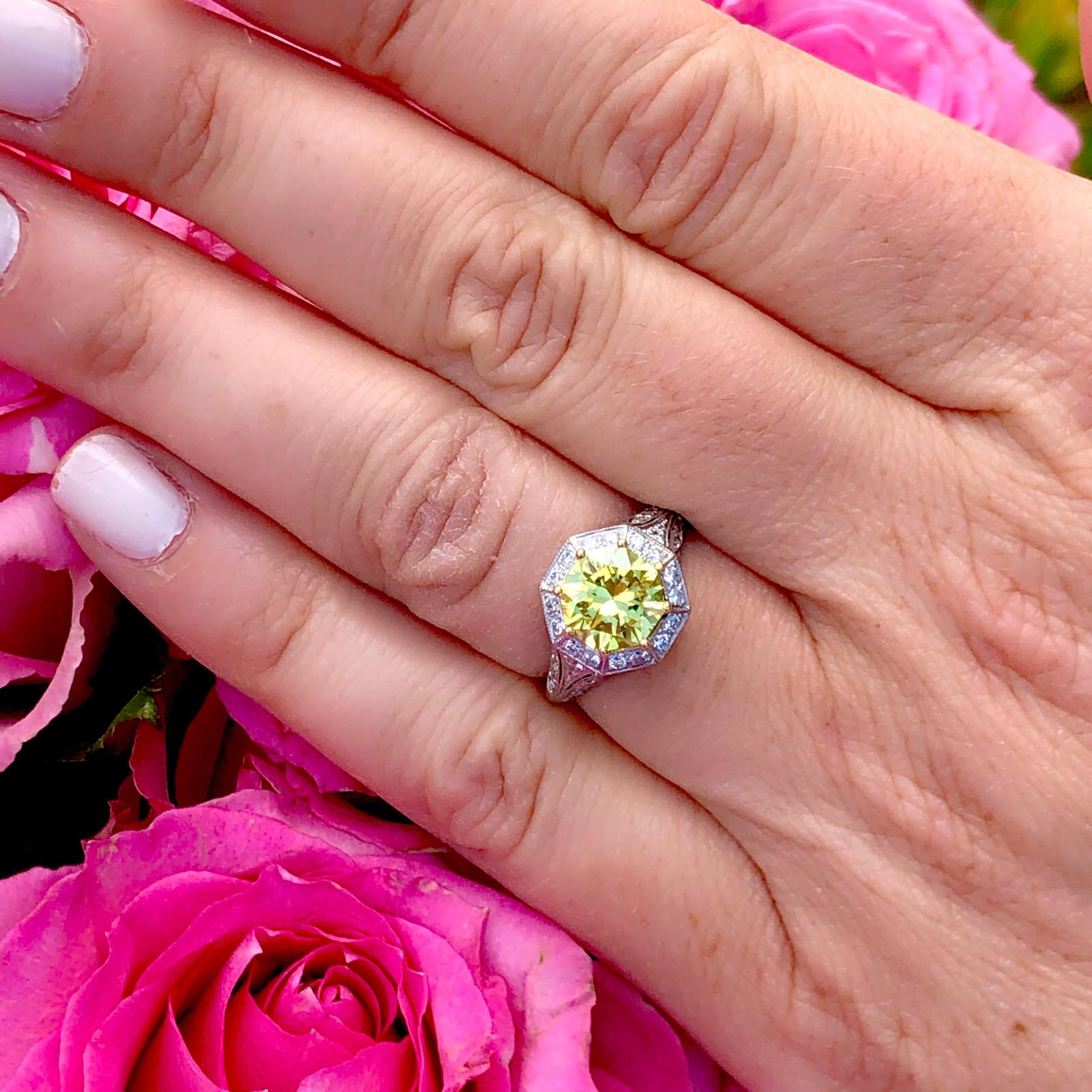 An extraordinary diamond set in an extraordinary custom French ring! This incredible piece showcases an impressive 1.88 carat GIA Fancy Intense Yellow Octagonal Cut Modified Brilliant Diamond set in a vintage inspired platinum mounting by French