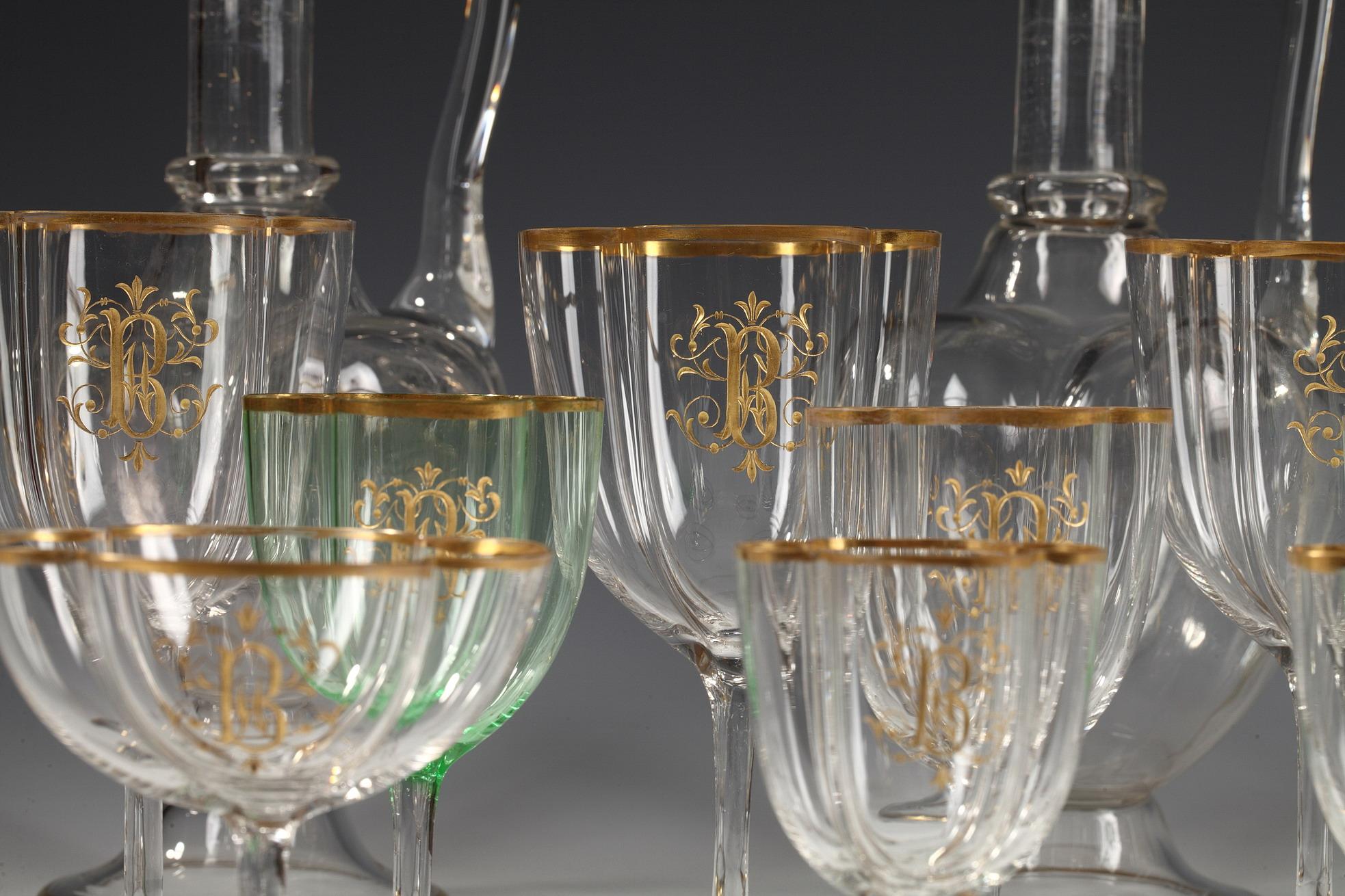 Cypher “B” set of 112 pieces. 

Glasses table set attributed to the crystal manufacture of Baccarat, composed by eighteen Champagne cups, twenty-two water glasses, twenty-two red wine glasses, twenty-two green-colored white wine glasses, eighteen